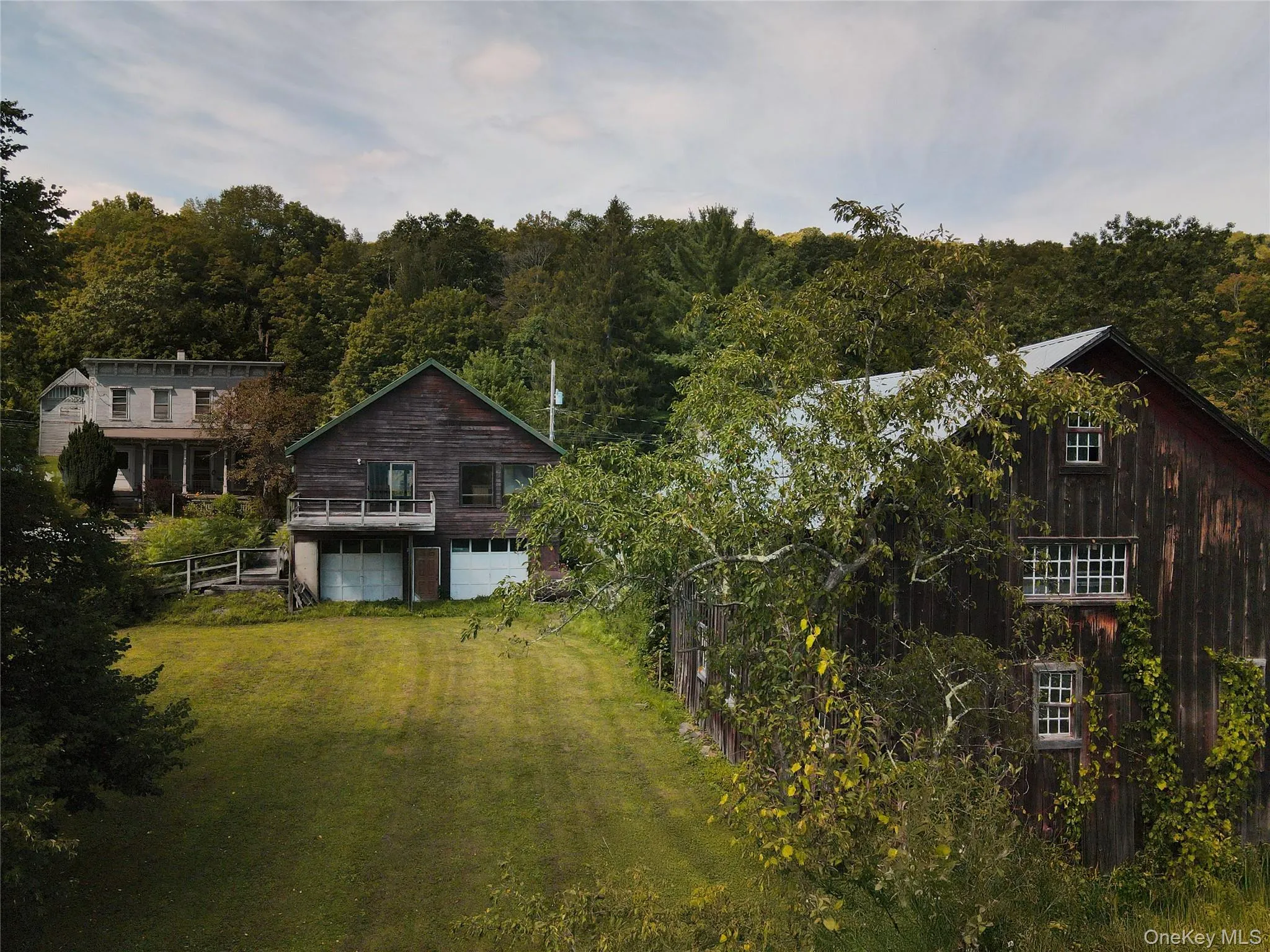 Back of house with a view of trees and driveway Back of house with a view of trees and driveway