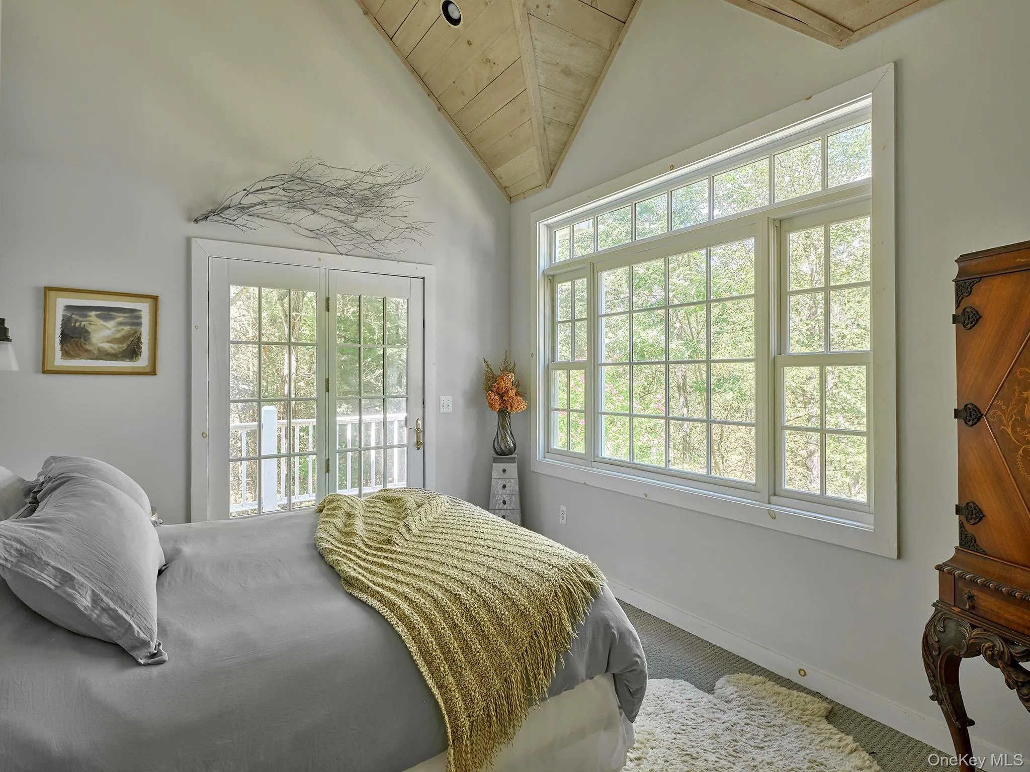 Carpeted bedroom featuring access to exterior, lofted ceiling, and wooden ceiling Carpeted bedroom featuring access to exterior, lofted ceiling, and wooden ceiling