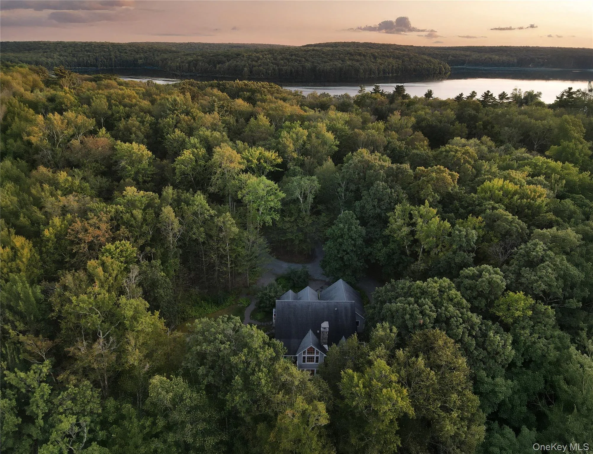 View of subject property featuring a heavily wooded area and a large body of water View of subject property featuring a heavily wooded area and a large body of water
