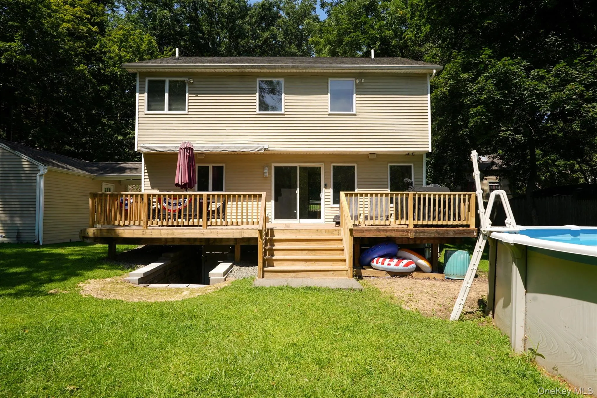 Part of the backyard, new deck with retractable awning, and above-ground swimming pool. Part of the backyard, new deck with retractable awning, and above-ground swimming pool.