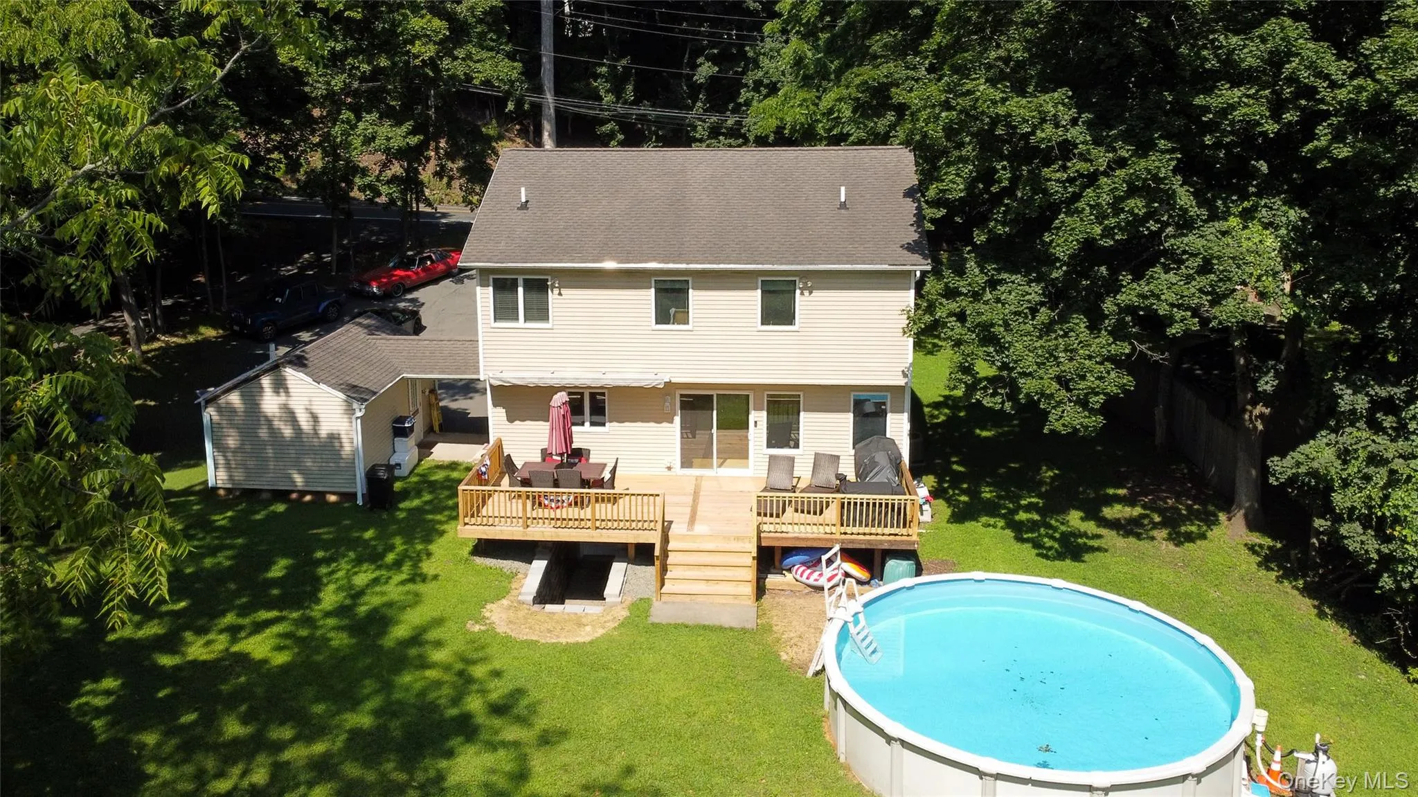Aerial view of part of the backyard, deck, breezeway, and detached garage. Aerial view of part of the backyard, deck, breezeway, and detached garage.