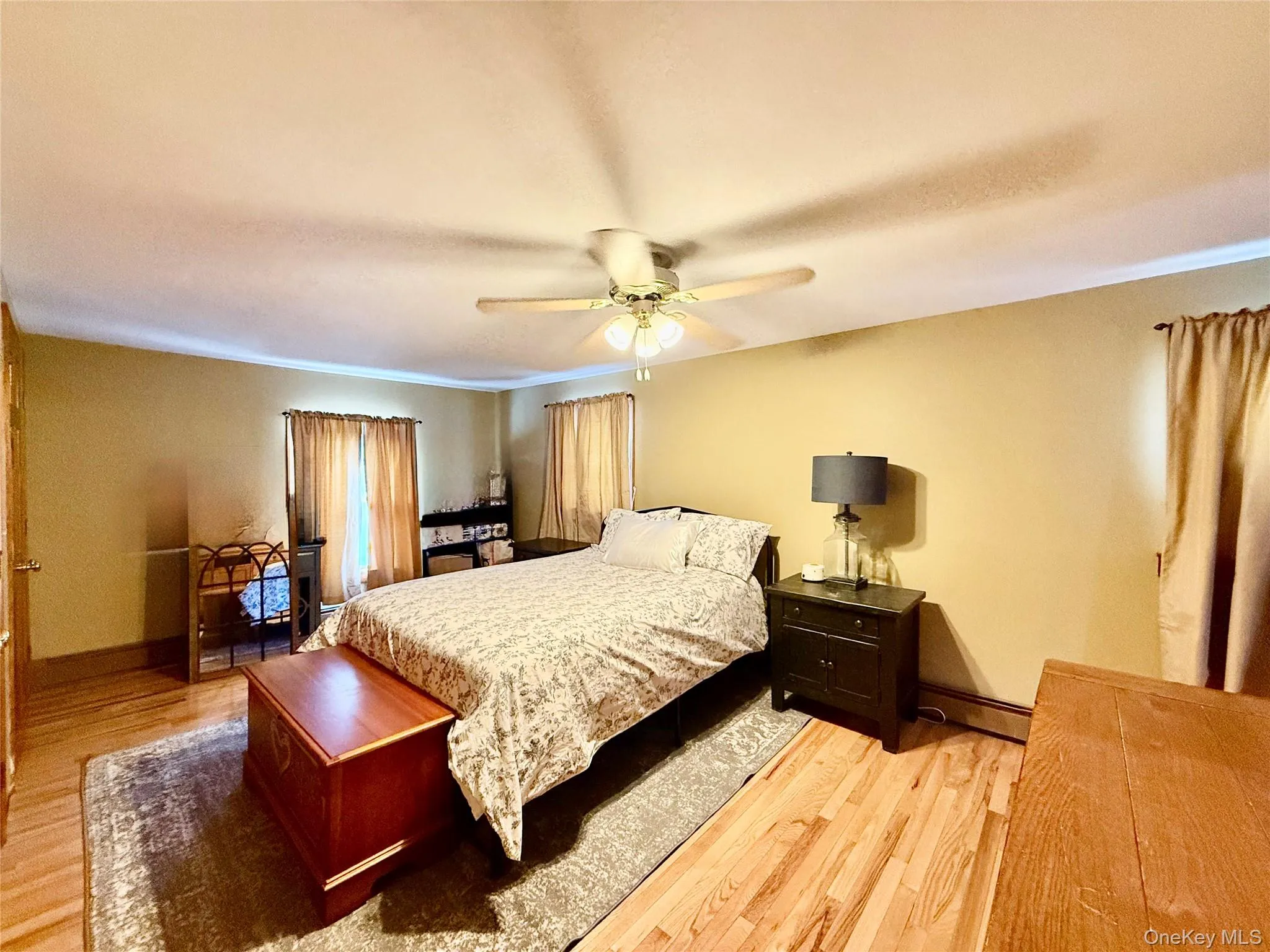 Bedroom with light wood-type flooring, a ceiling fan, a baseboard radiator, and crown molding Bedroom with light wood-type flooring, a ceiling fan, a baseboard radiator, and crown molding