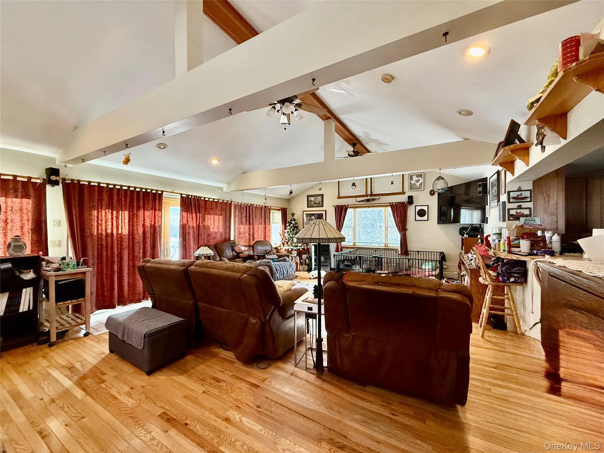 Living room featuring light wood-style flooring, lofted ceiling, healthy amount of natural light, recessed lighting, and a ceiling fan Living room featuring light wood-style flooring, lofted ceiling, healthy amount of natural light, recessed lighting, and a ceiling fan