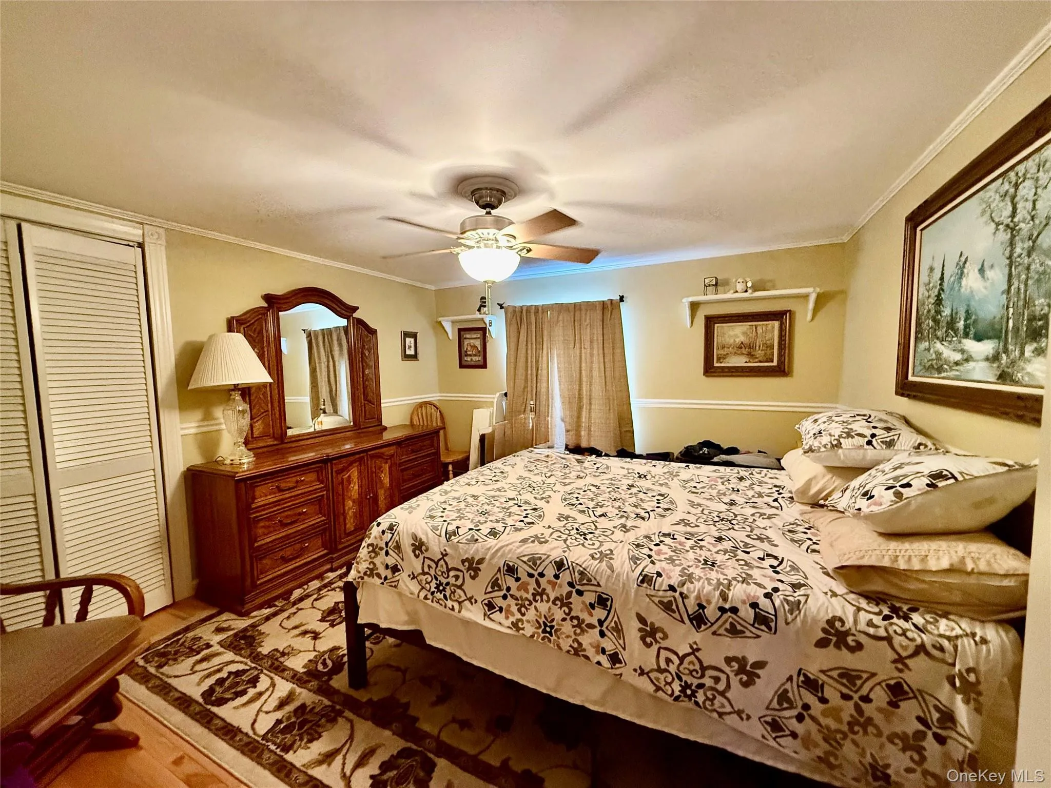 Bedroom with a closet, crown molding, a ceiling fan, and light wood finished floors Bedroom with a closet, crown molding, a ceiling fan, and light wood finished floors