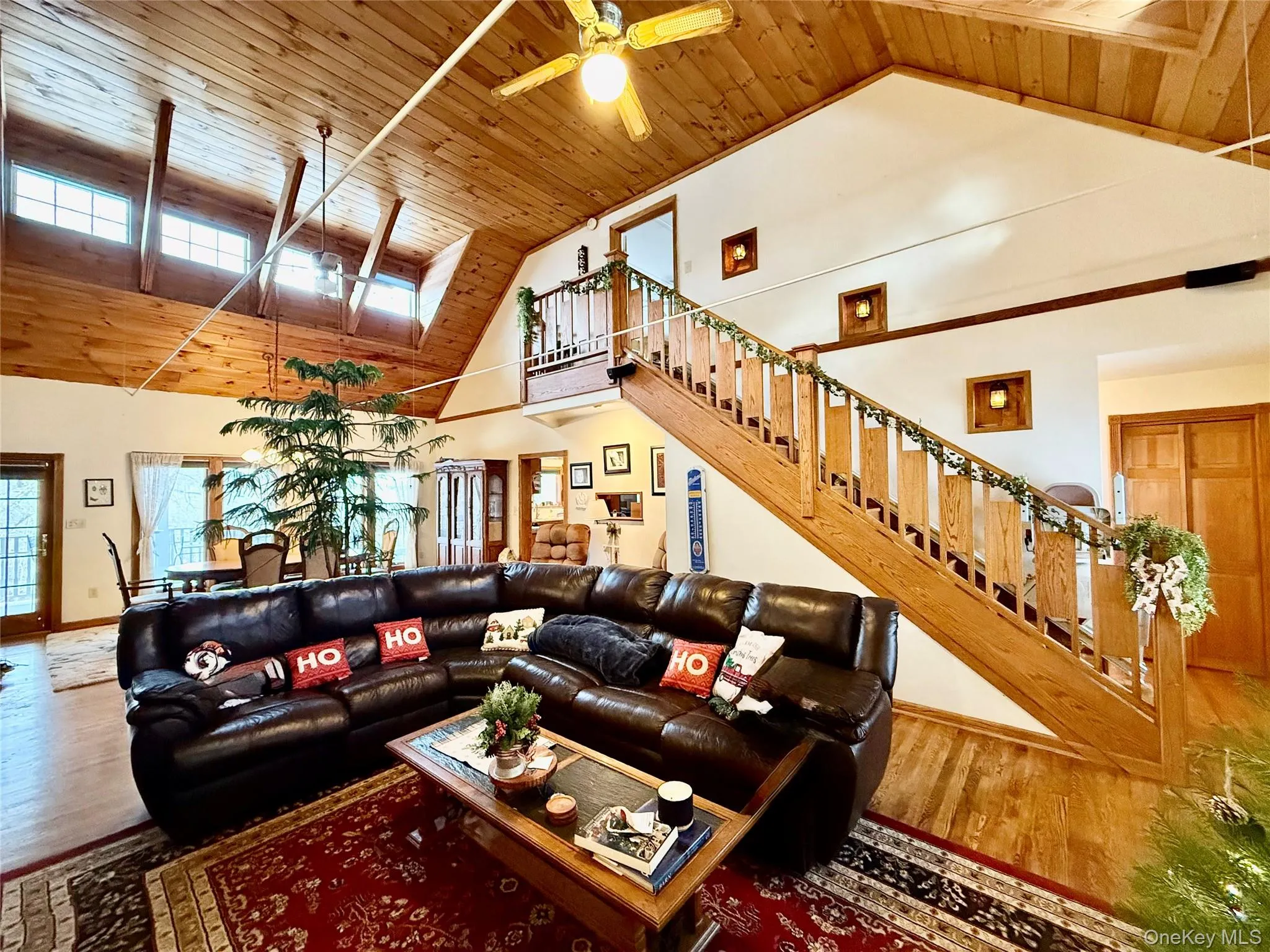 Living room with a high wood ceiling, a ceiling fan, and wood finished floors Living room with a high wood ceiling, a ceiling fan, and wood finished floors