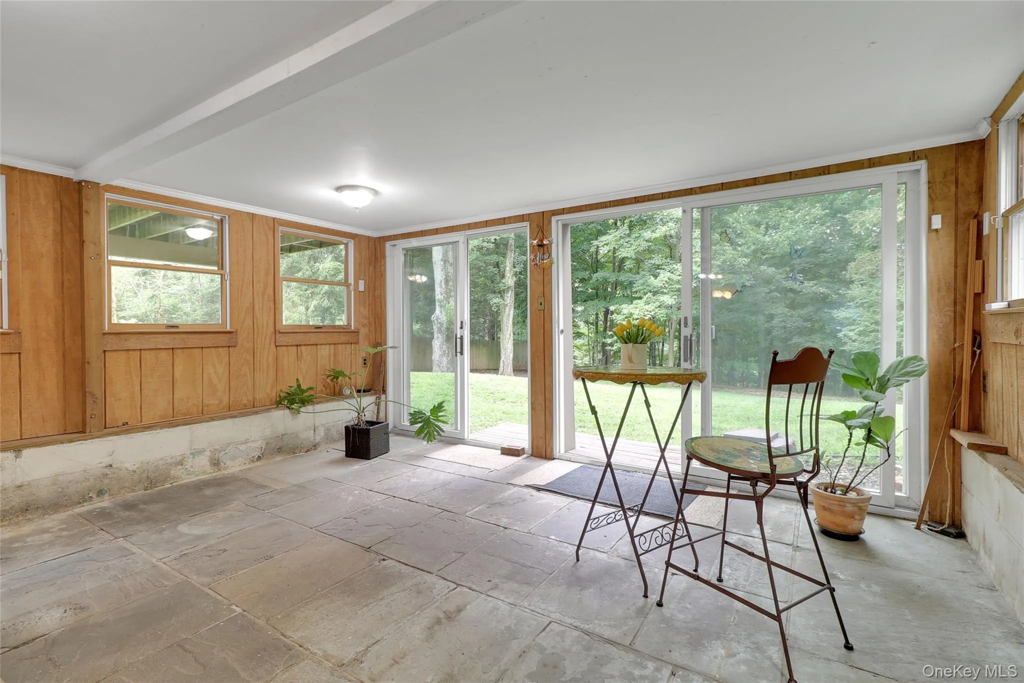 Large sunroom with flagstone floors and sliding glass doors to private back yard Large sunroom with flagstone floors and sliding glass doors to private back yard