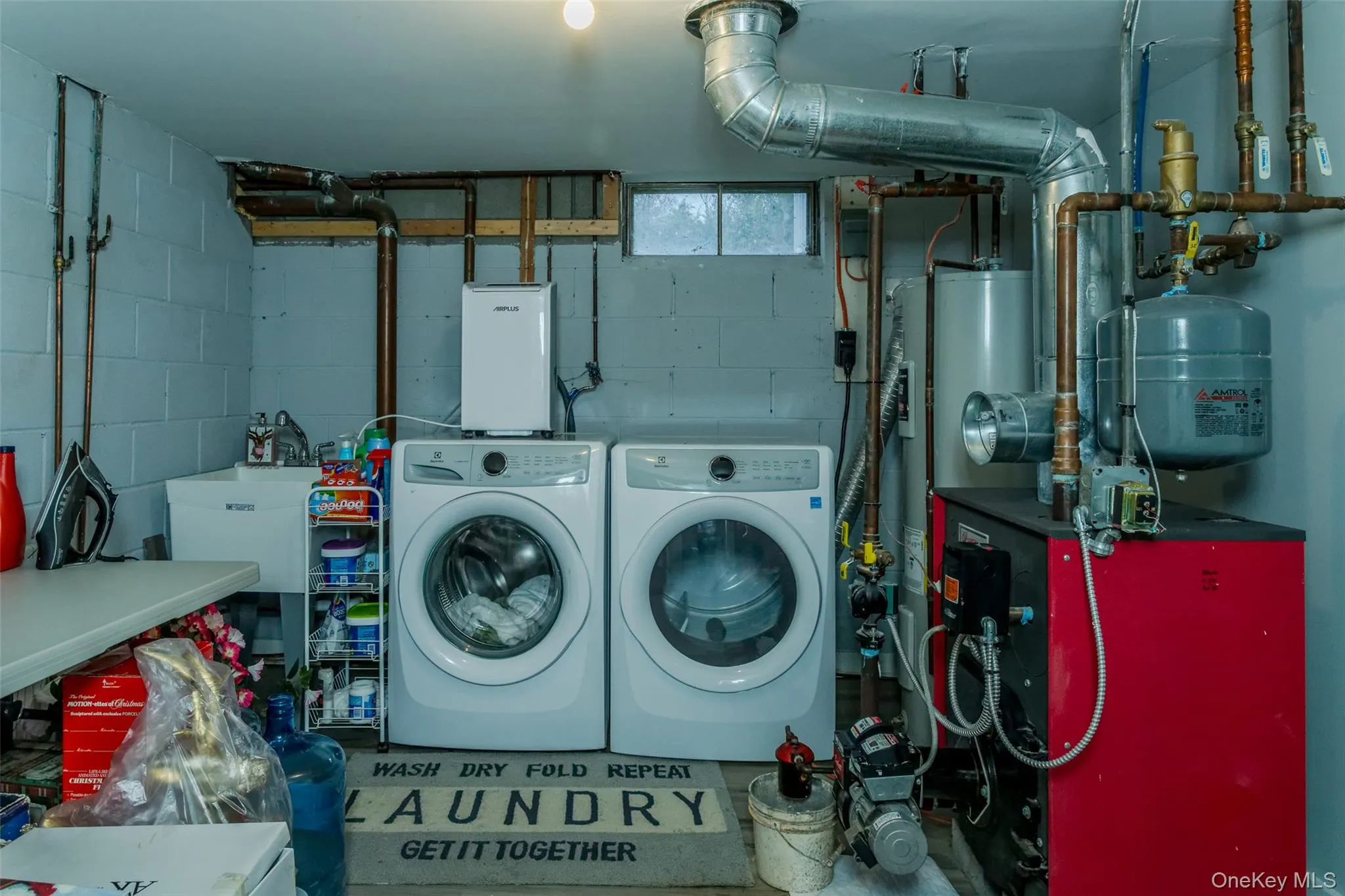 Laundry room featuring gas water heater, washer and clothes dryer, and sink Laundry room featuring gas water heater, washer and clothes dryer, and sink