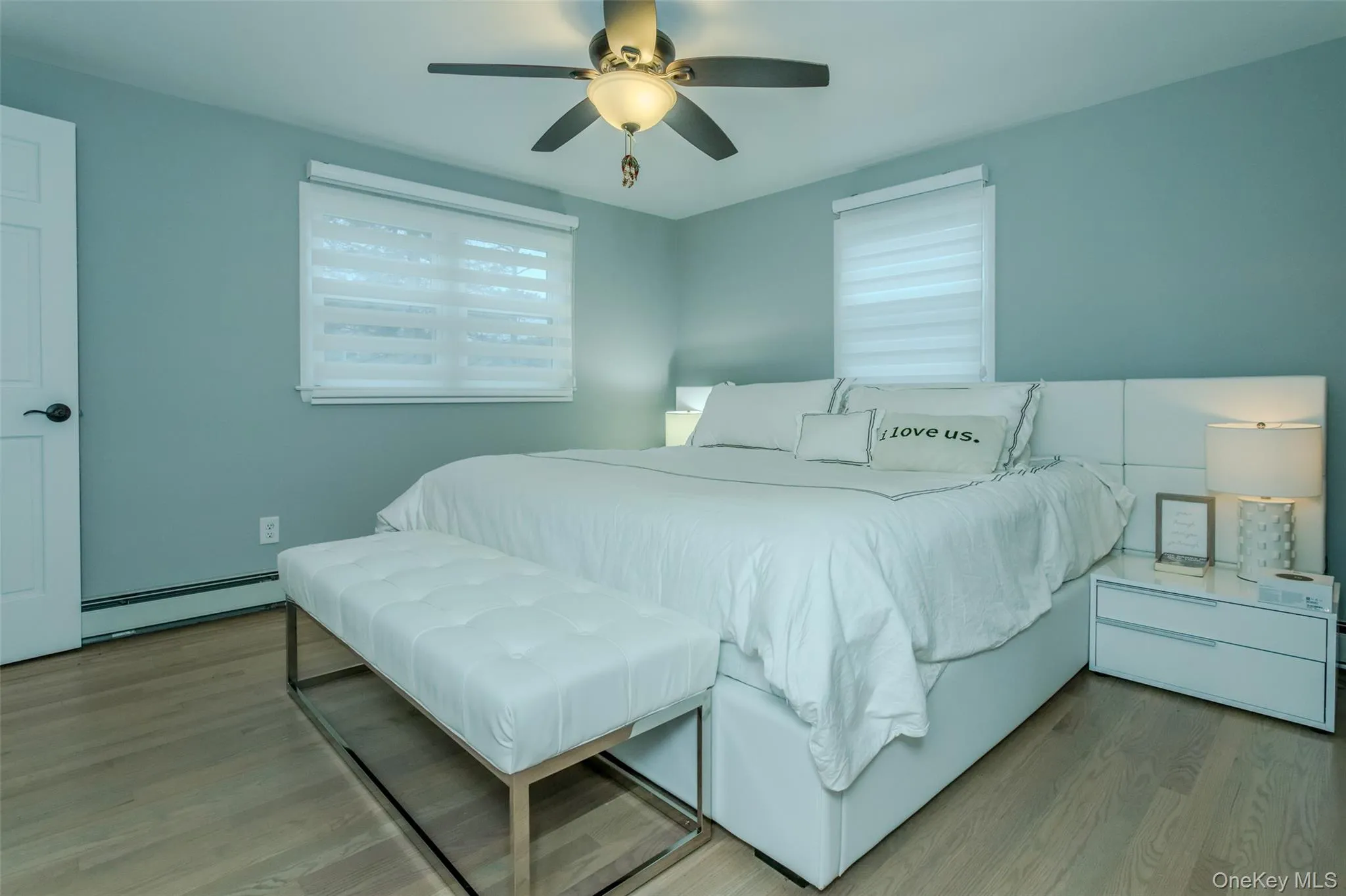 Bedroom with ceiling fan, light wood-type flooring, and a baseboard radiator Bedroom with ceiling fan, light wood-type flooring, and a baseboard radiator