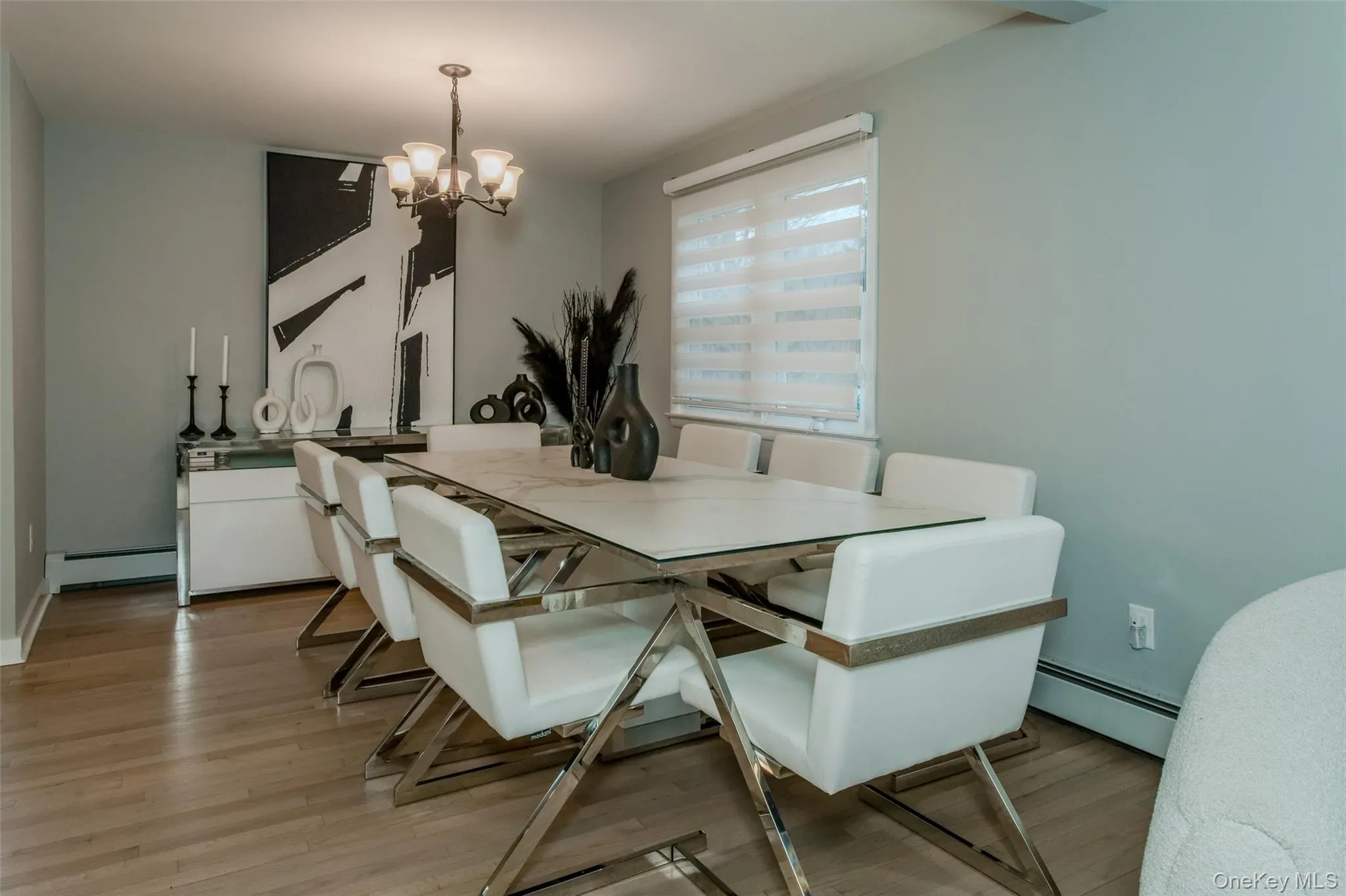 Dining space with a chandelier, a baseboard radiator, and light hardwood / wood-style floors Dining space with a chandelier, a baseboard radiator, and light hardwood / wood-style floors