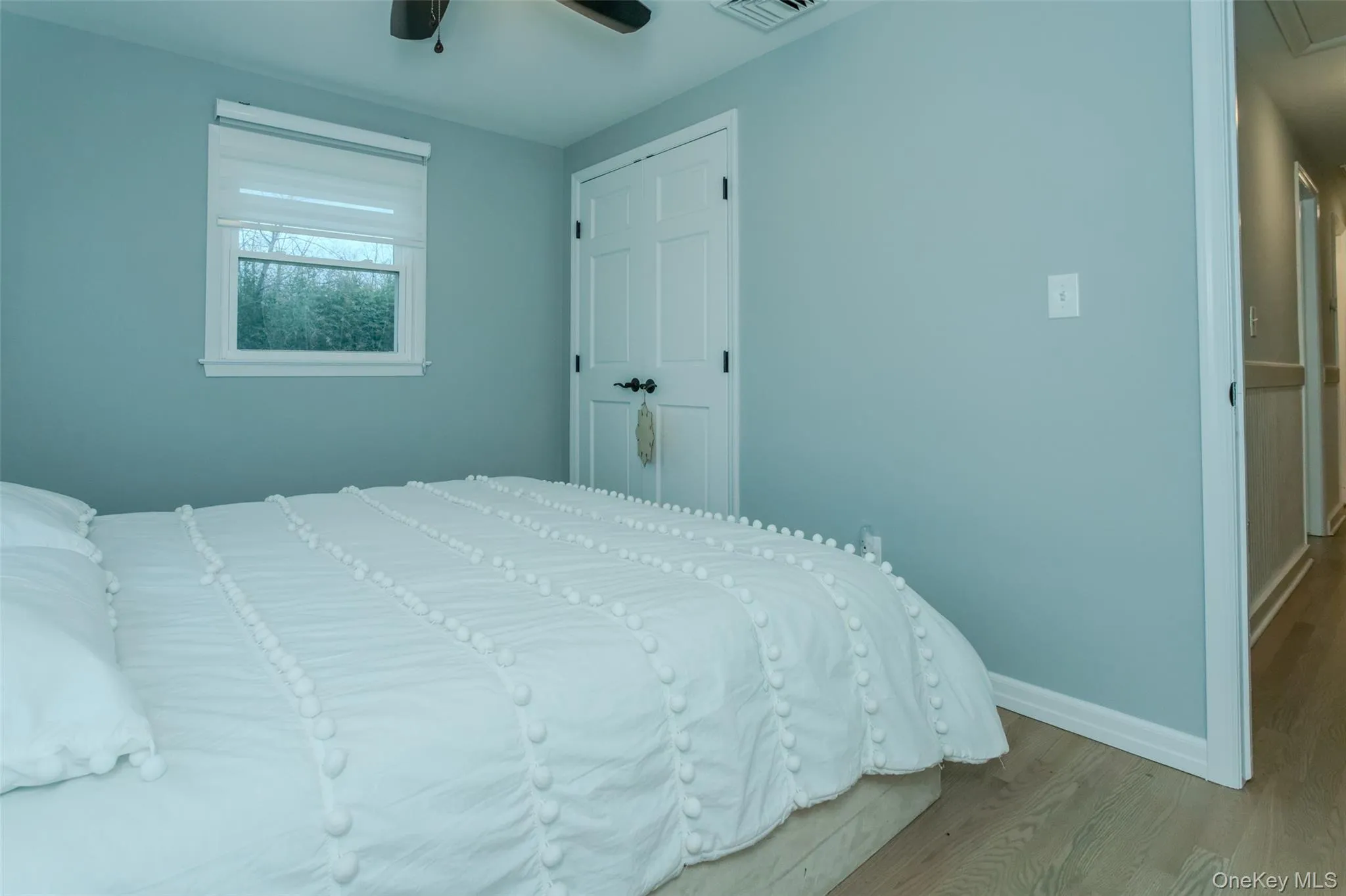 Bedroom featuring ceiling fan, light wood-type flooring, and a closet Bedroom featuring ceiling fan, light wood-type flooring, and a closet