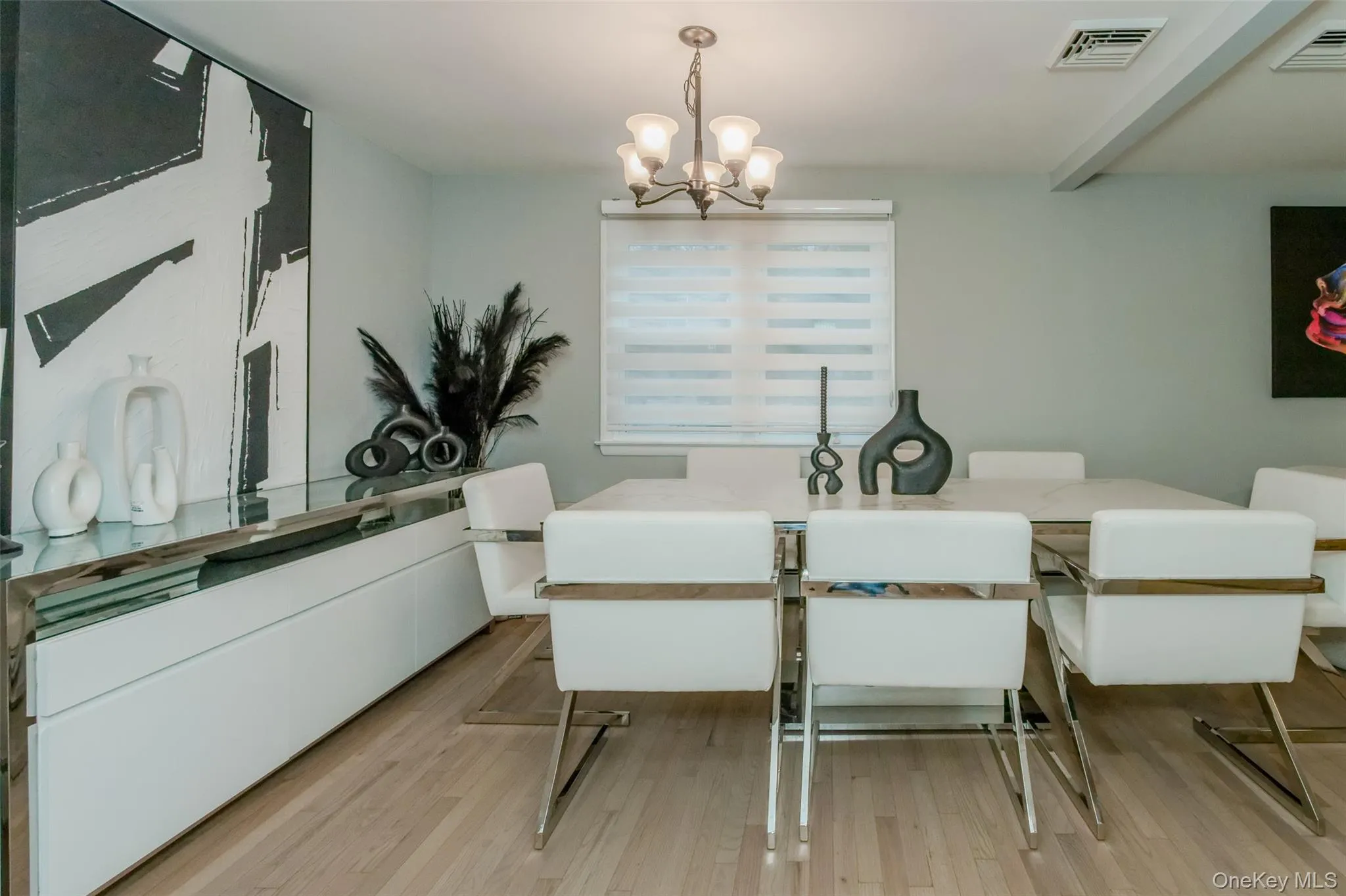 Dining room featuring a notable chandelier and light wood-type flooring Dining room featuring a notable chandelier and light wood-type flooring