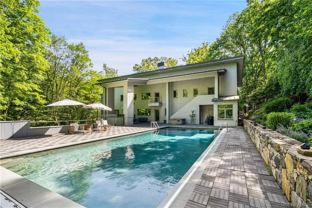 Back of property with a patio, stucco siding, and a chimney Back of property with a patio, stucco siding, and a chimney