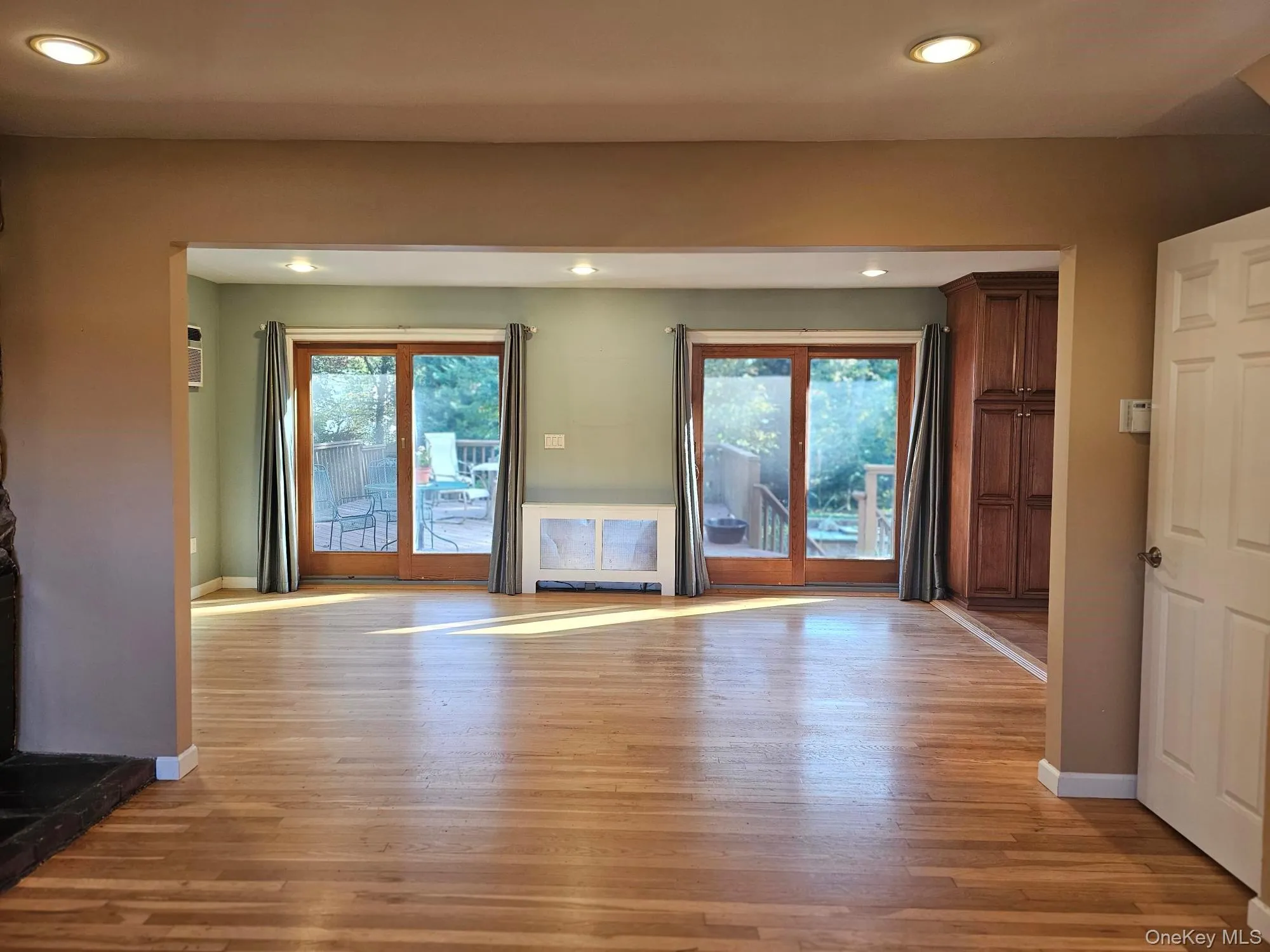Open Floor Plan View of Living Room into Den with Sliding Doors to Backyard Deck Open Floor Plan View of Living Room into Den with Sliding Doors to Backyard Deck