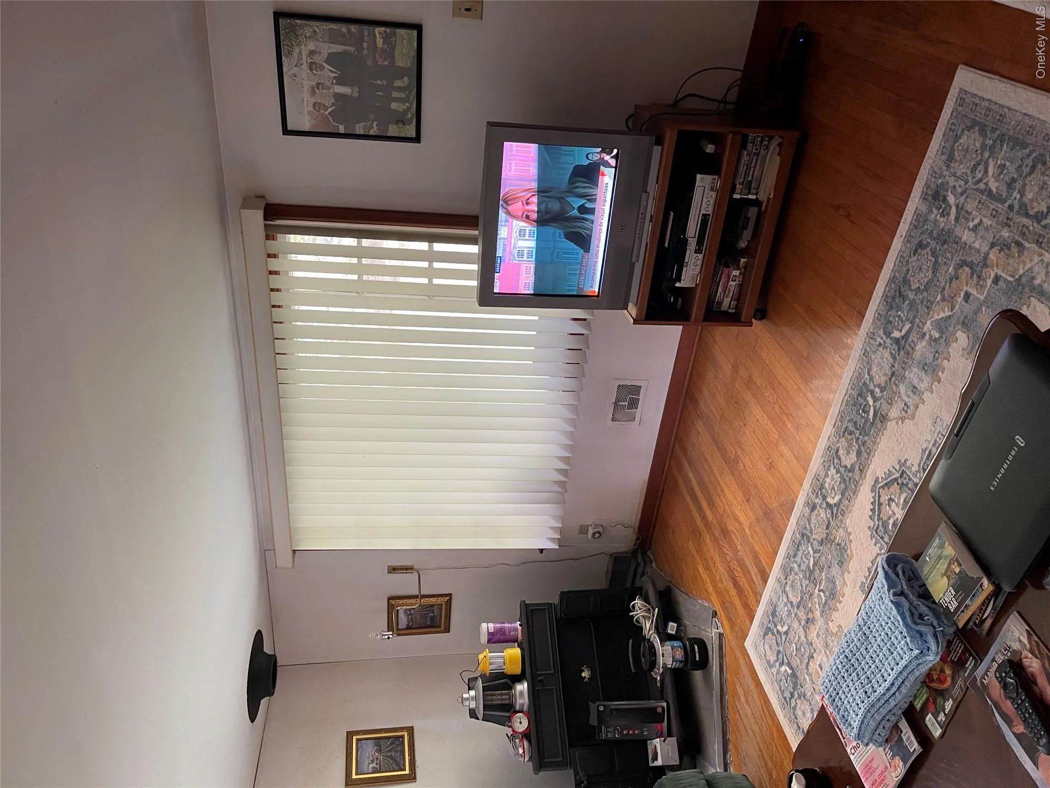 Hardwood-style flooring throughout, complemented by a large window with vertical blinds Hardwood-style flooring throughout, complemented by a large window with vertical blinds