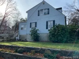 View of side of property featuring a yard and a wooden deck View of side of property featuring a yard and a wooden deck