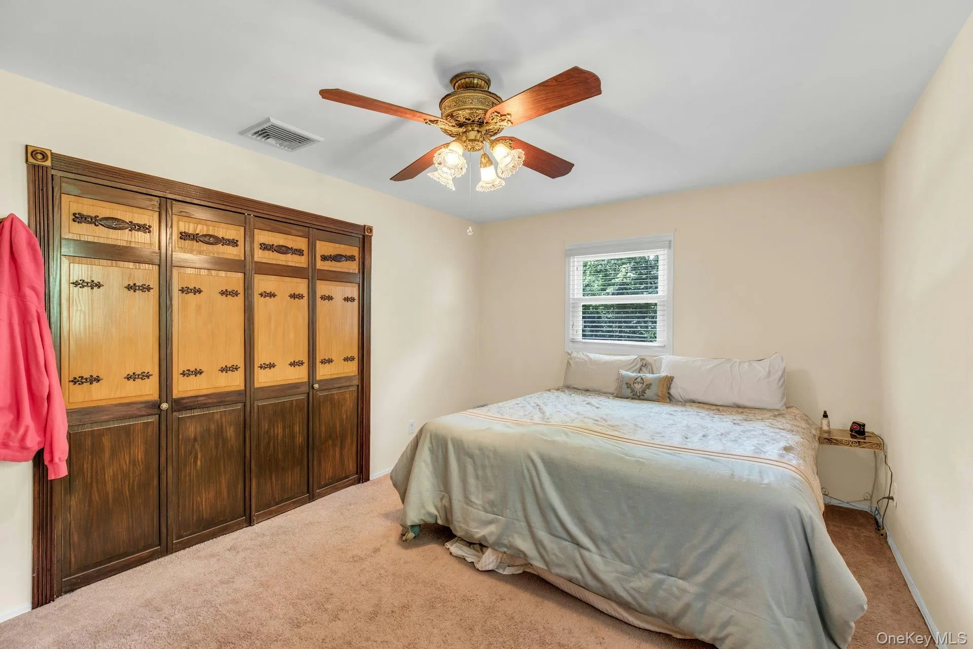 Bedroom with Built-in closet system with bi-fold doors, two-tone wood paneling, and decorative hardware Bedroom with Built-in closet system with bi-fold doors, two-tone wood paneling, and decorative hardware