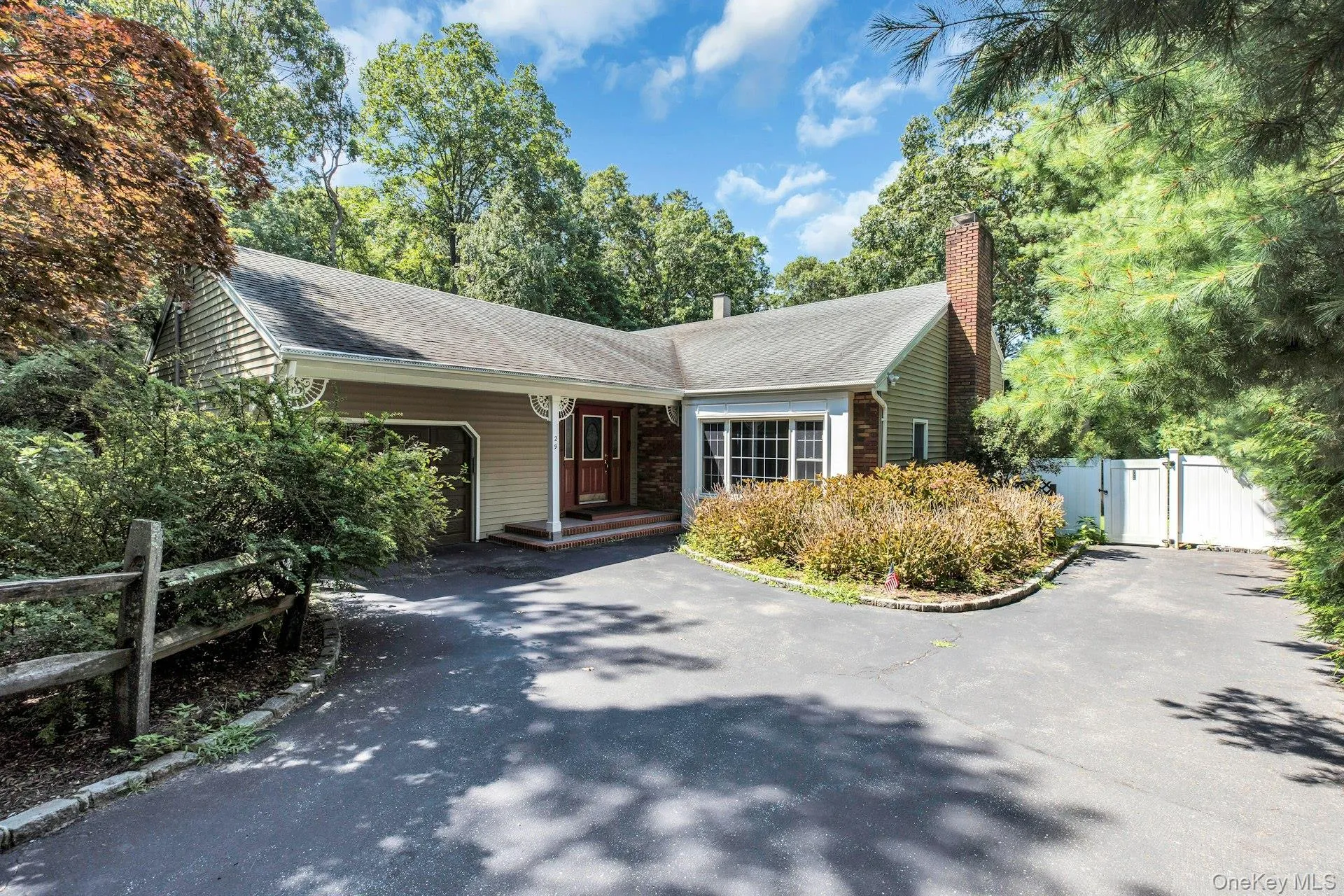 Charming ranch-style home featuring a welcoming brick chimney, composite siding exterior, and asphalt driveway Charming ranch-style home featuring a welcoming brick chimney, composite siding exterior, and asphalt driveway
