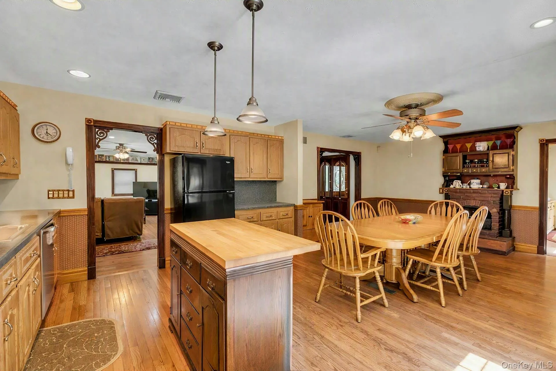 Kitchen featuring wood-finish flooring, recessed lighting, and a dark wood island with a butcher block countertop Kitchen featuring wood-finish flooring, recessed lighting, and a dark wood island with a butcher block countertop