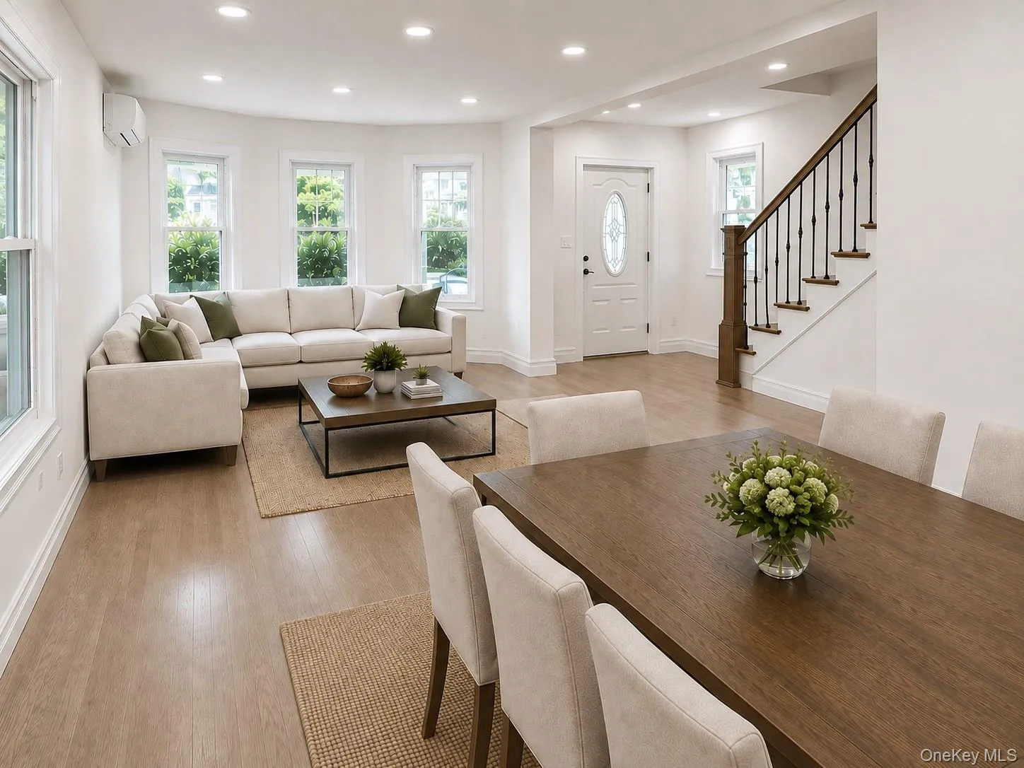 Open-concept living area featuring light wood-finish flooring, recessed lighting, and ample natural light from multiple windows Open-concept living area featuring light wood-finish flooring, recessed lighting, and ample natural light from multiple windows