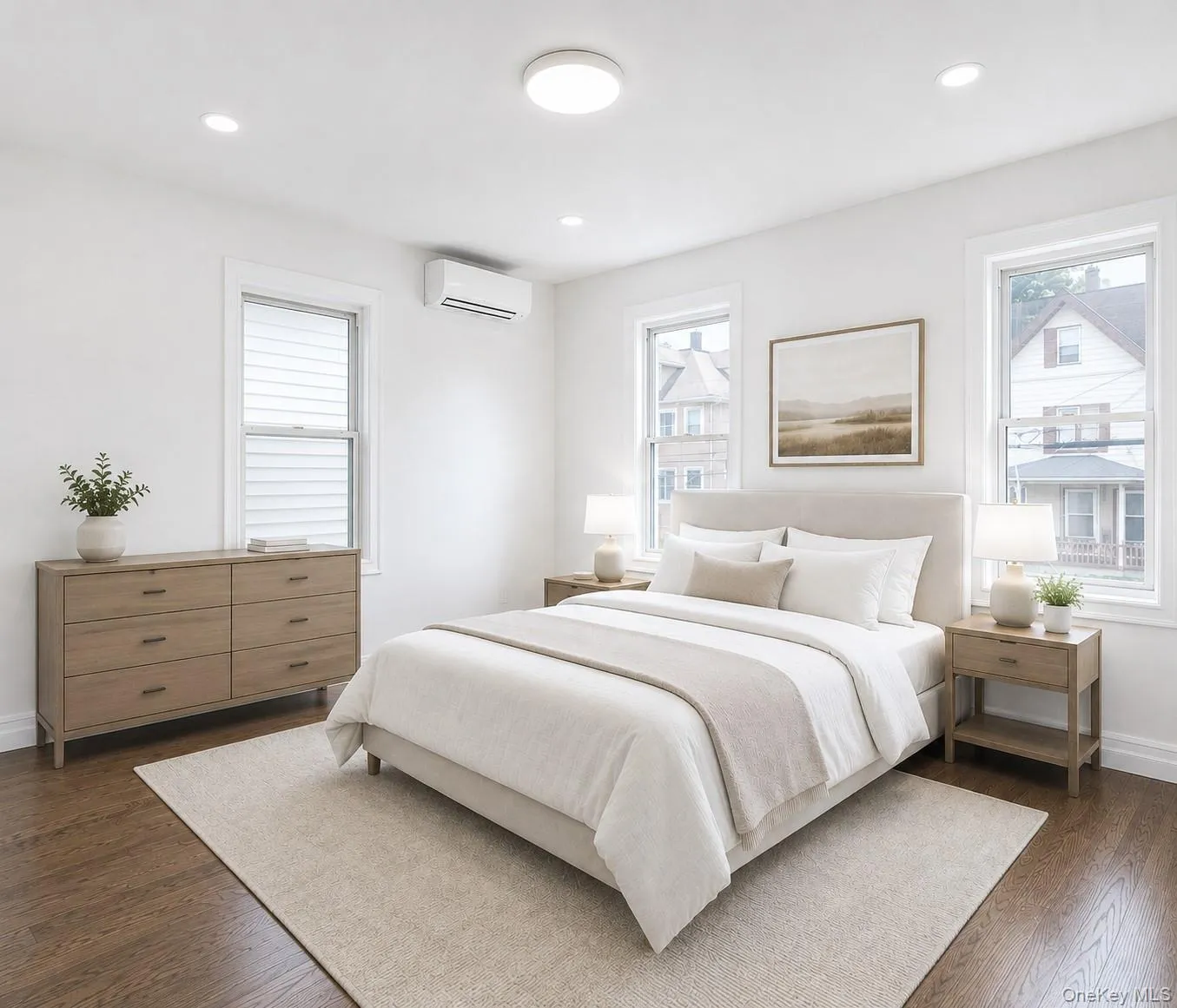 Primary bedroom featuring rich wood-finish flooring, white walls, and recessed lighting Primary bedroom featuring rich wood-finish flooring, white walls, and recessed lighting