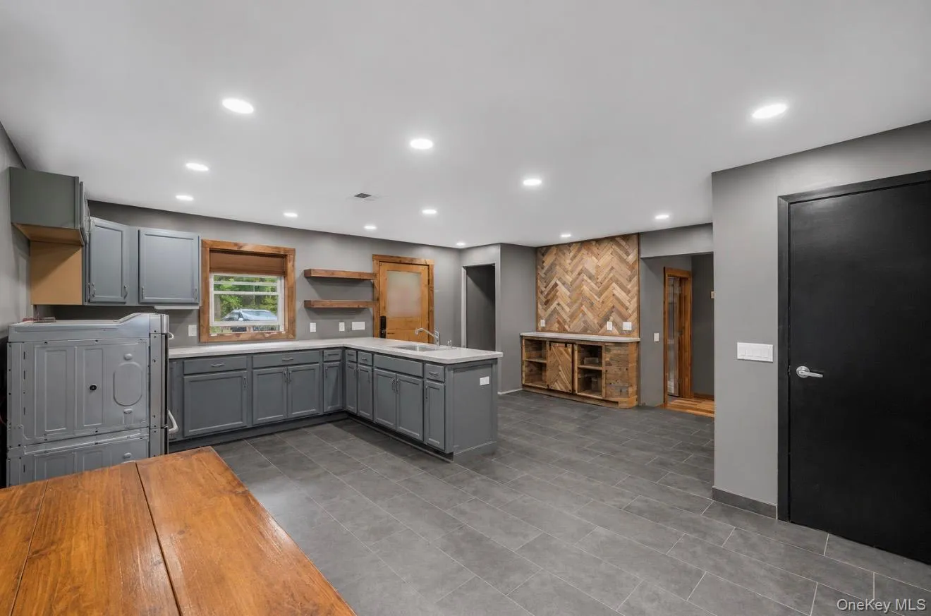 Spacious kitchen area featuring gray cabinetry, light countertops, a built-in sink, and recessed lighting Spacious kitchen area featuring gray cabinetry, light countertops, a built-in sink, and recessed lighting
