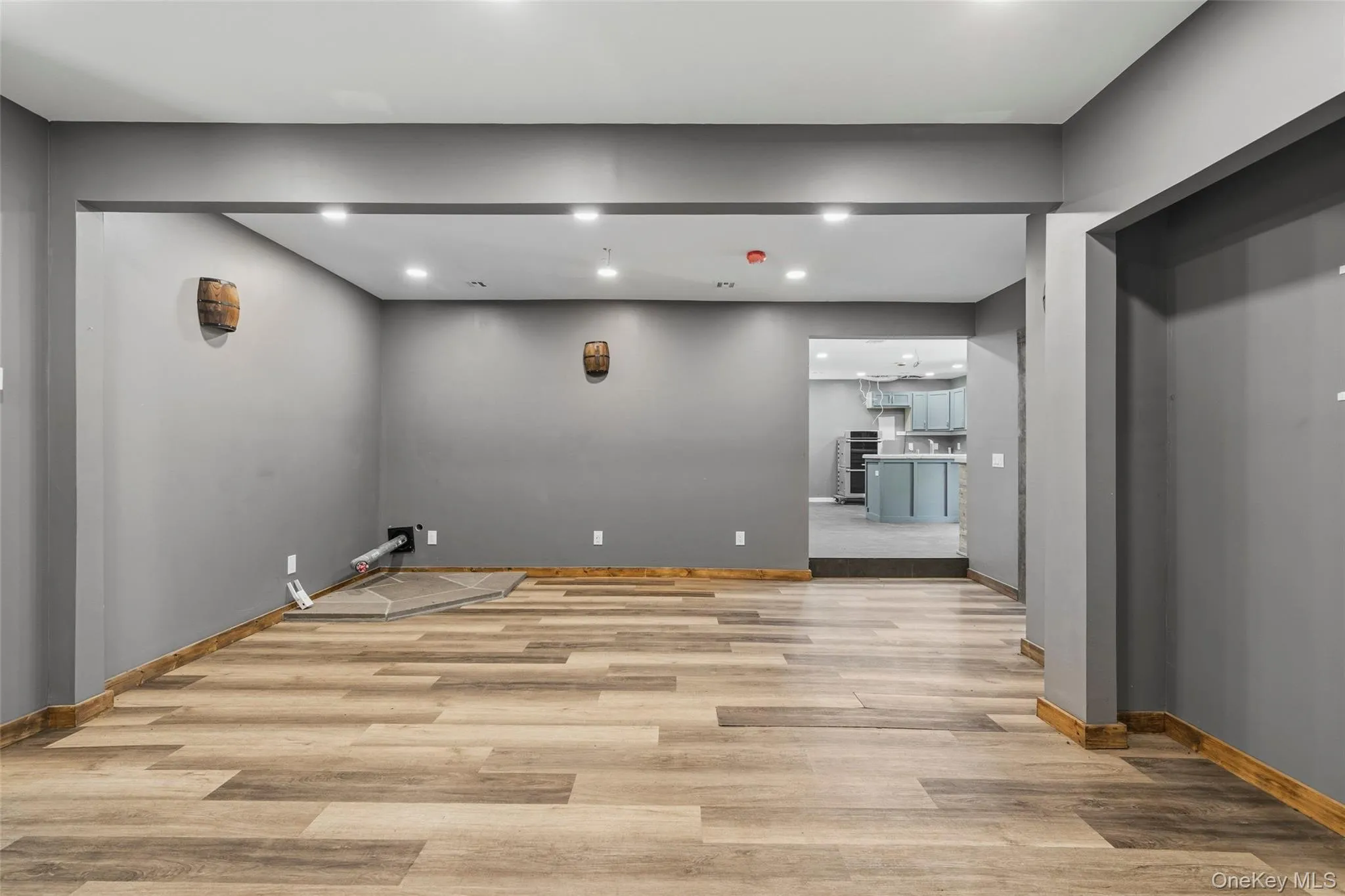 Living room with recessed lighting, luxury vinyl flooring, and pellet stove hook-up Living room with recessed lighting, luxury vinyl flooring, and pellet stove hook-up