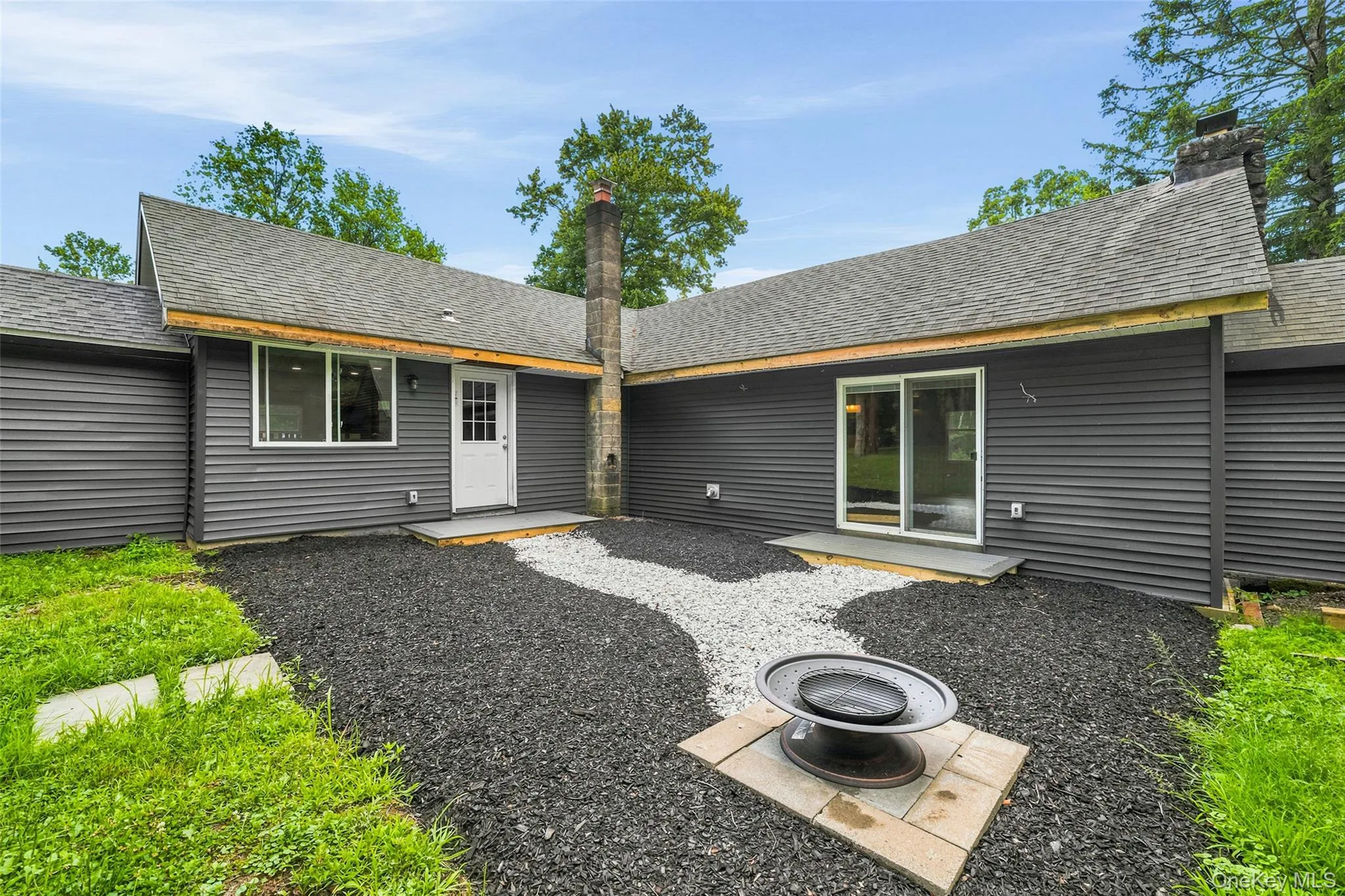 Private outdoor courtyard featuring a fire pit, fresh landscaping, and easy access to the home's living space. Private outdoor courtyard featuring a fire pit, fresh landscaping, and easy access to the home's living space.