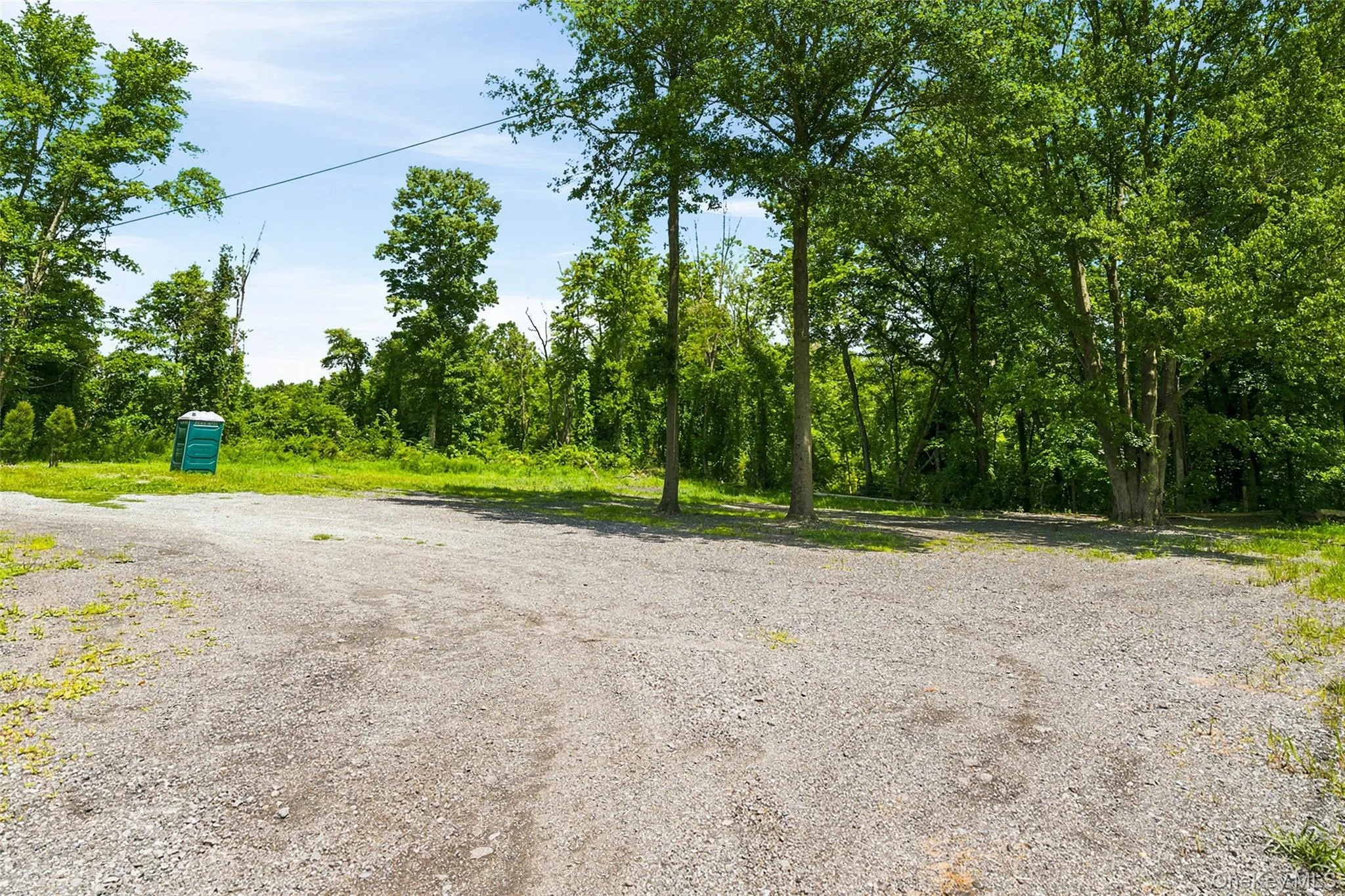 Expansive gravel parking area with ample space for multiple vehicles, trucks, trailers, RVs, and recreational equipment Expansive gravel parking area with ample space for multiple vehicles, trucks, trailers, RVs, and recreational equipment