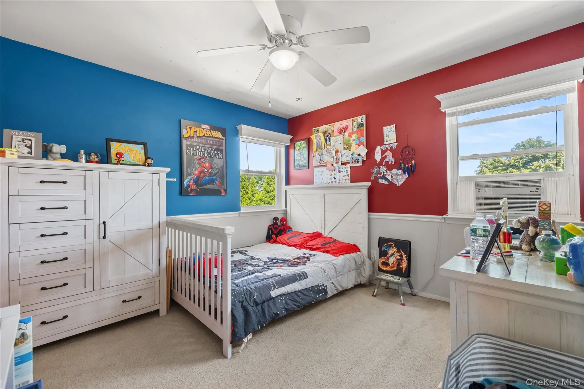 Spacious room featuring carpeting, two windows with white trim, and a ceiling fan Spacious room featuring carpeting, two windows with white trim, and a ceiling fan