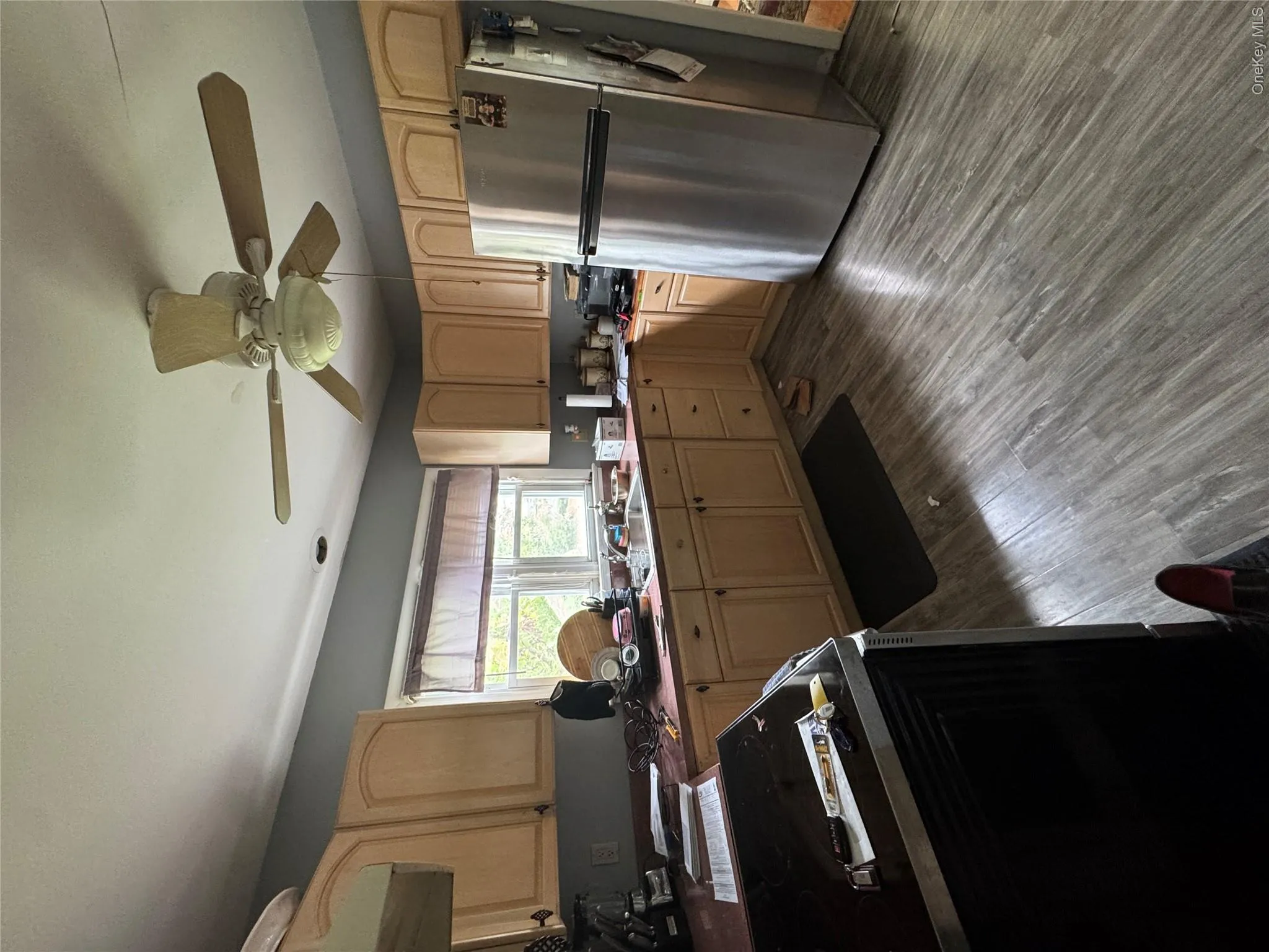 Kitchen featuring light wood-finish cabinetry, a stainless steel refrigerator, and wood-look flooring Kitchen featuring light wood-finish cabinetry, a stainless steel refrigerator, and wood-look flooring