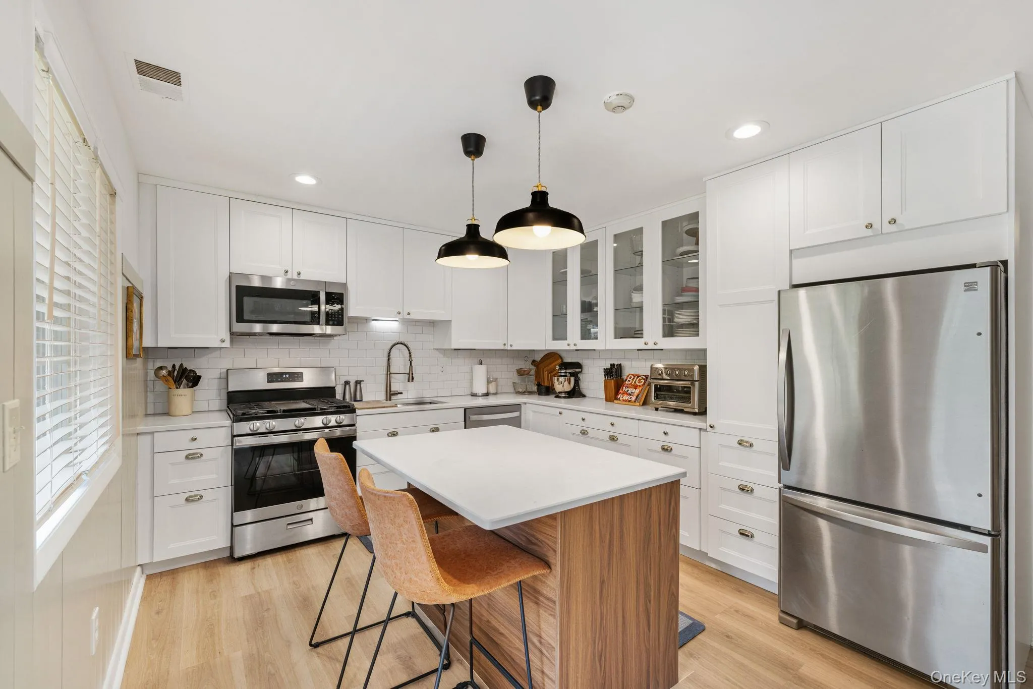 Recently renovated kitchen with stainless steel appliances, quartz counters, and an island. Recently renovated kitchen with stainless steel appliances, quartz counters, and an island.