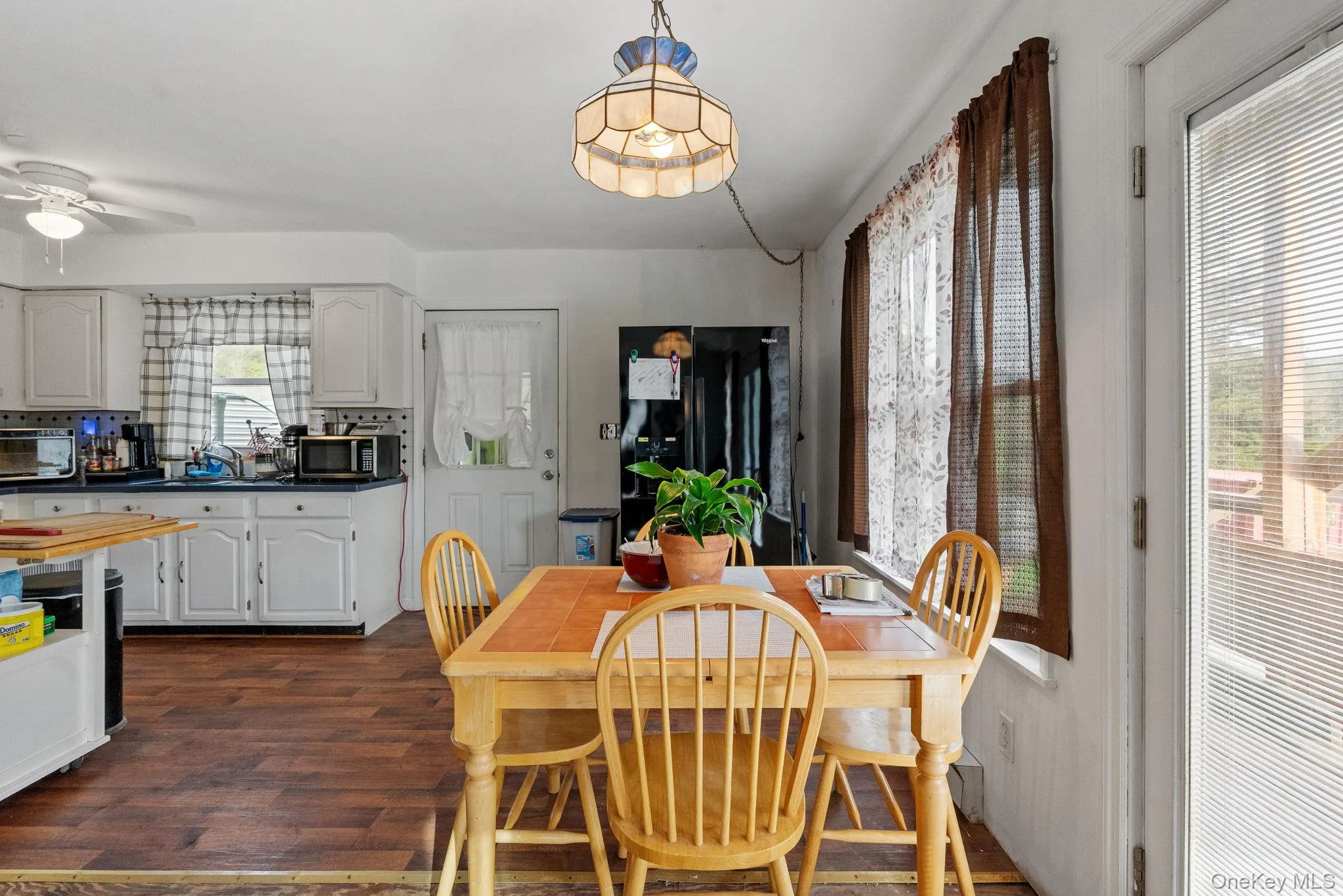 Dining space with dark wood-style floors and a ceiling fan Dining space with dark wood-style floors and a ceiling fan