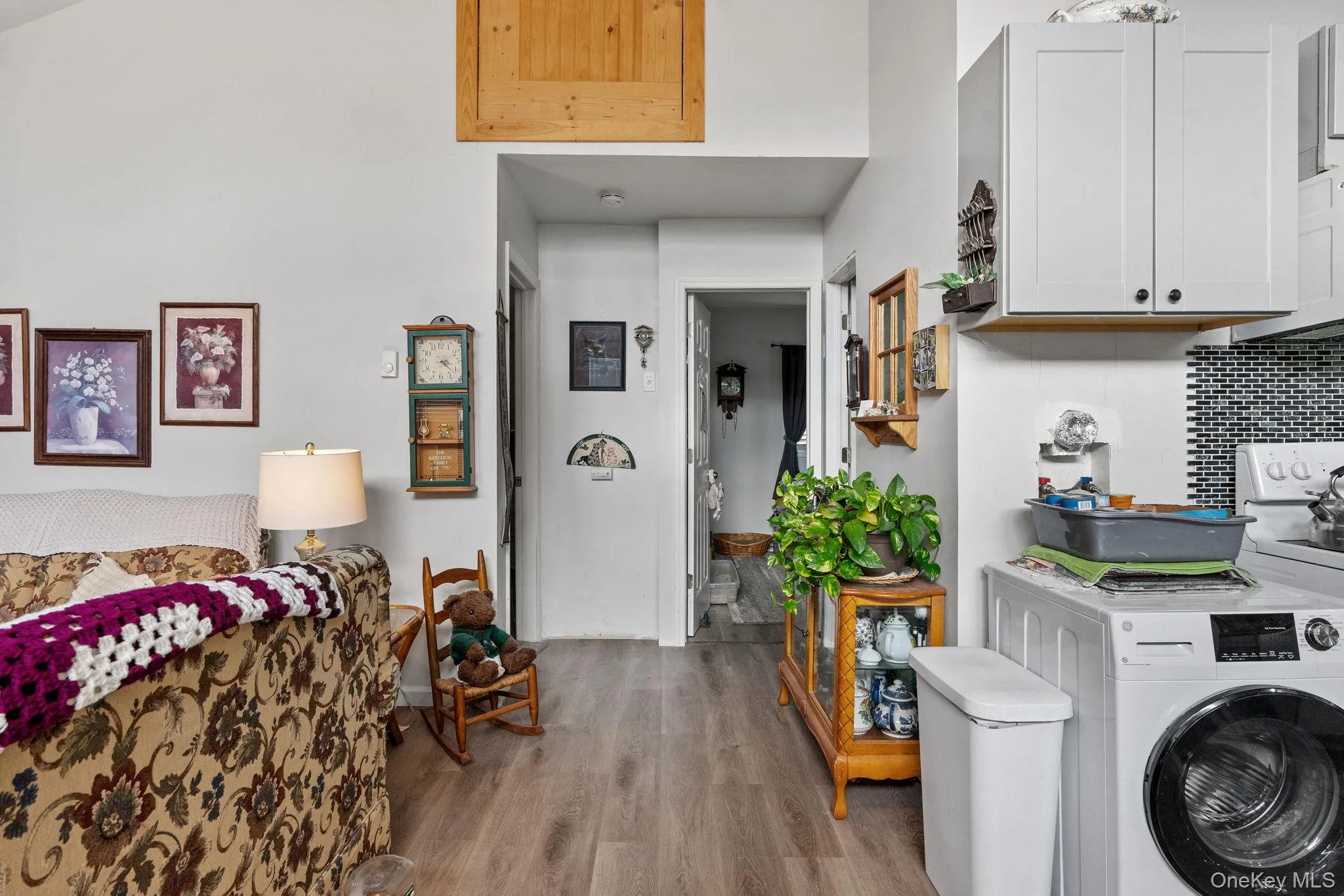 Washroom featuring washer / clothes dryer, wood finished floors, and cabinet space Washroom featuring washer / clothes dryer, wood finished floors, and cabinet space