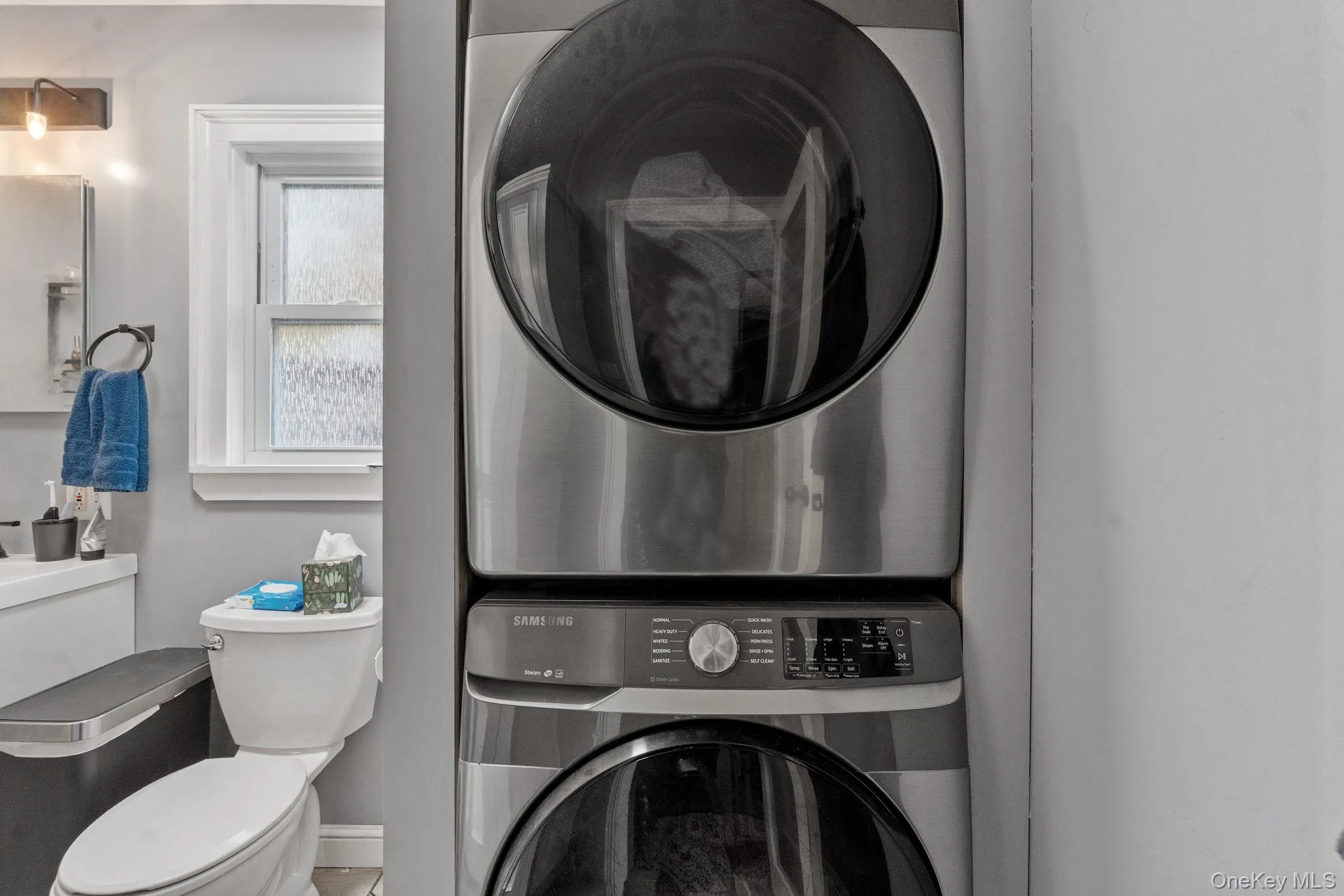 Laundry room with stacked washing machine and dryer and baseboards Laundry room with stacked washing machine and dryer and baseboards