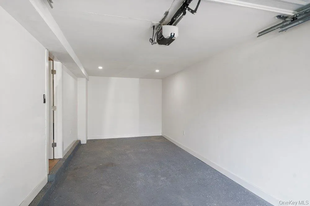 Spacious Attached 1.5 Car Garage features polished concrete flooring, white walls, and recessed lighting throughout Spacious Attached 1.5 Car Garage features polished concrete flooring, white walls, and recessed lighting throughout