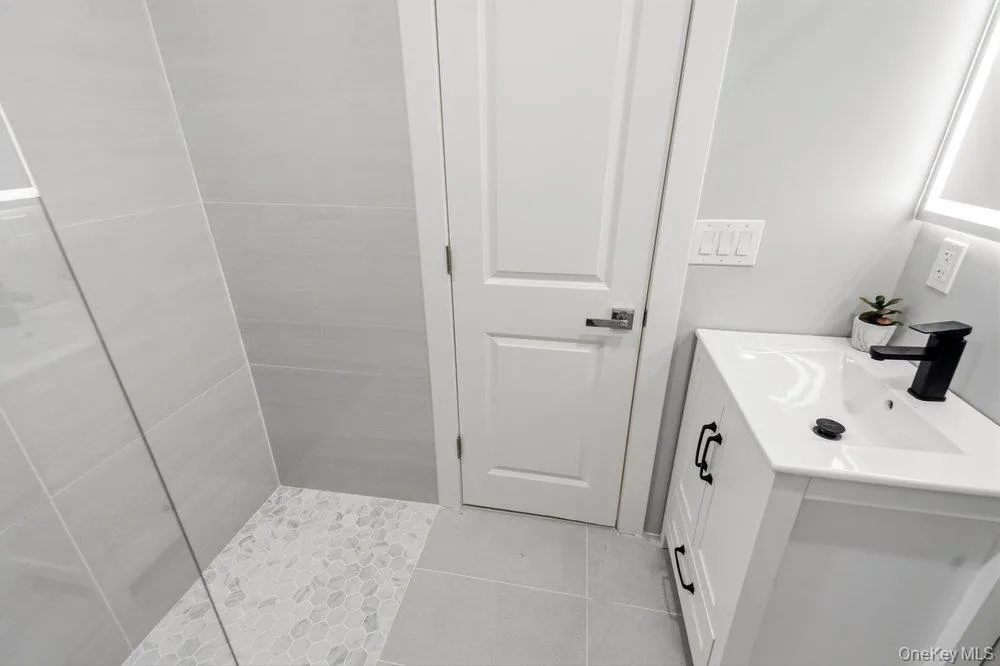 2nd Bedroom Ensute Bath featuring a white vanity with integrated sink, matte black faucet, and contemporary square handles 2nd Bedroom Ensute Bath featuring a white vanity with integrated sink, matte black faucet, and contemporary square handles