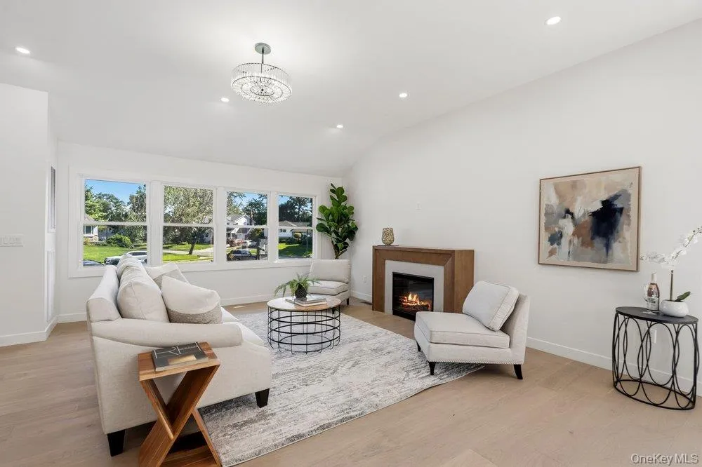 Light-Bright-Cheery Rooms with Oak flooring, contemporary fireplace with a wood surround, and a vaulted ceiling with recessed lighting Light-Bright-Cheery Rooms with Oak flooring, contemporary fireplace with a wood surround, and a vaulted ceiling with recessed lighting