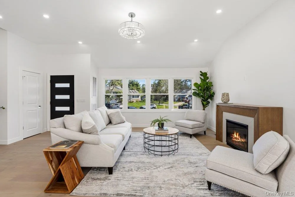 Beautiful Windows over looking the Exterior with an Open-concept living area featuring a vaulted ceiling and wood-finish flooring Beautiful Windows over looking the Exterior with an Open-concept living area featuring a vaulted ceiling and wood-finish flooring