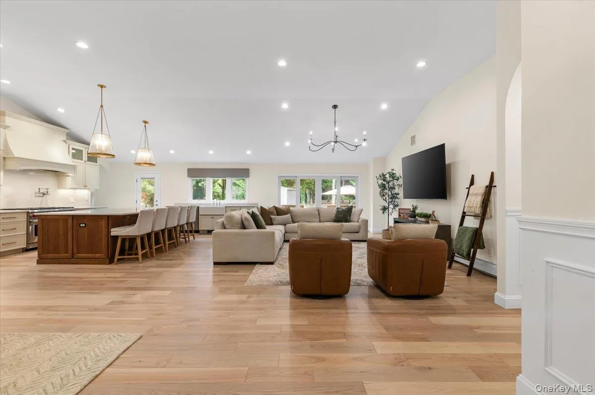 Vaulted ceiling, recessed lighting, wood-finish flooring, kitchen island, and wainscoting Vaulted ceiling, recessed lighting, wood-finish flooring, kitchen island, and wainscoting