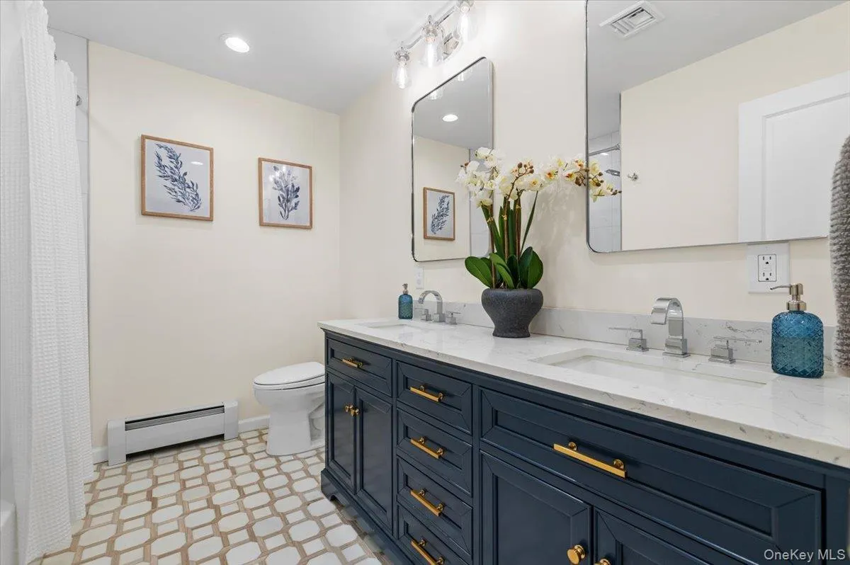 Dual vanity with white countertop, undermount sinks, and chrome faucets Dual vanity with white countertop, undermount sinks, and chrome faucets