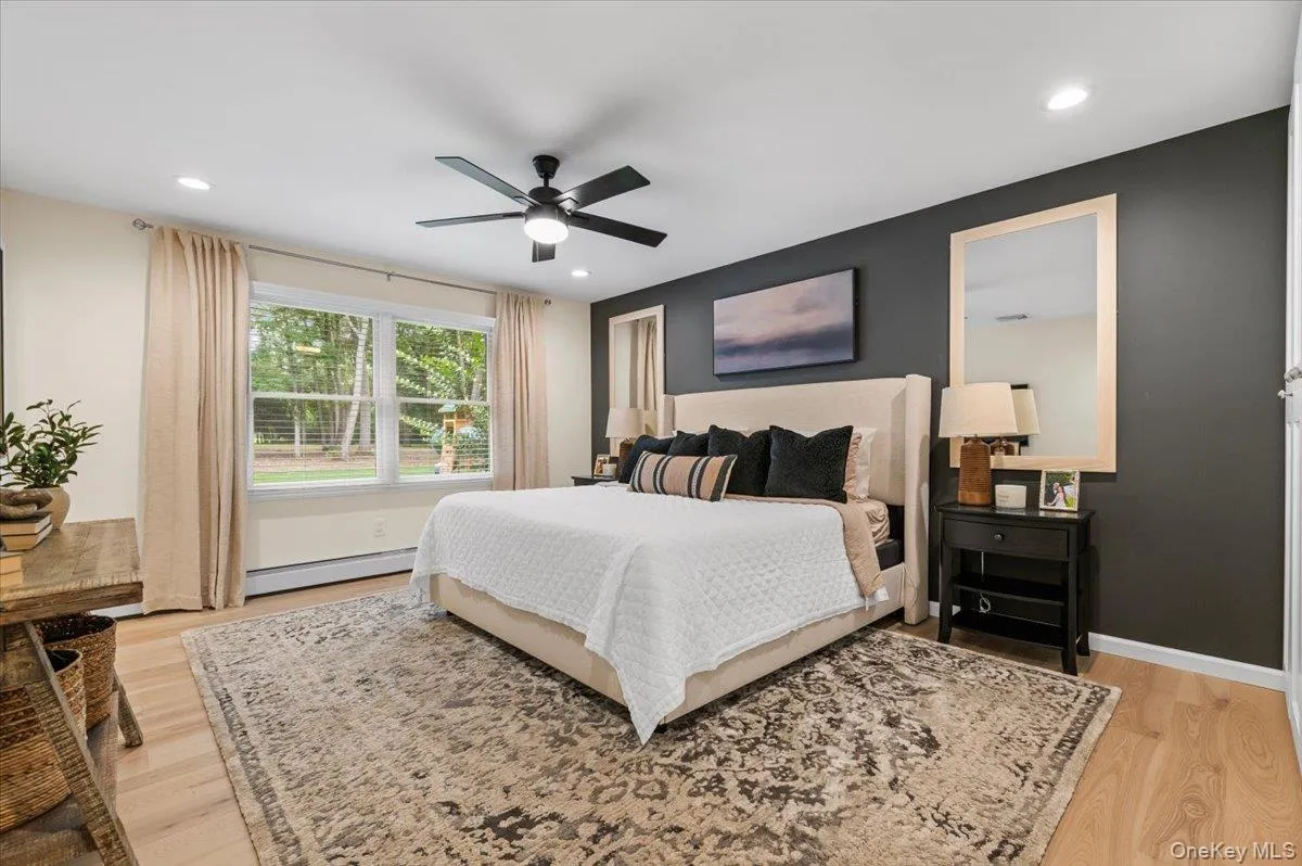 Light wood-finish flooring, recessed lighting, and a ceiling fan with integrated light Light wood-finish flooring, recessed lighting, and a ceiling fan with integrated light