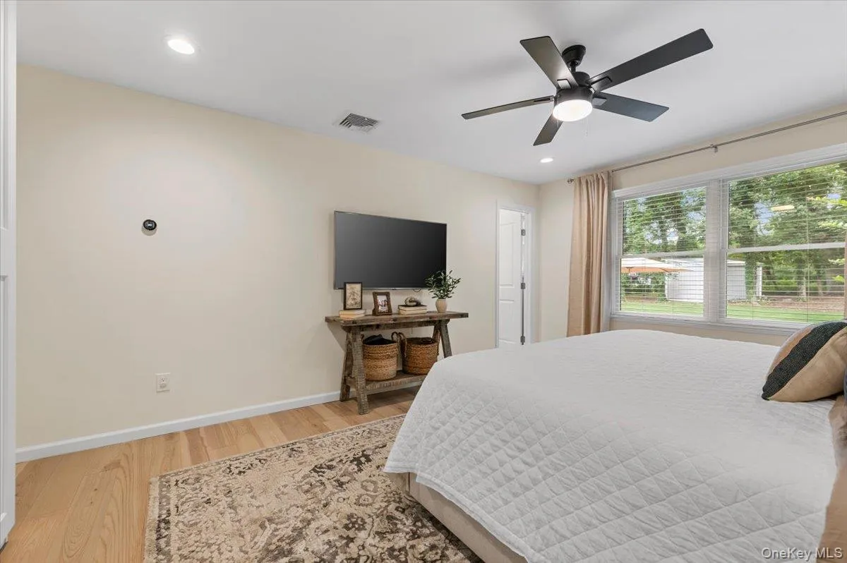 Recessed lighting, wood-finish flooring, ceiling fan, large windows, and wall-mounted display Recessed lighting, wood-finish flooring, ceiling fan, large windows, and wall-mounted display