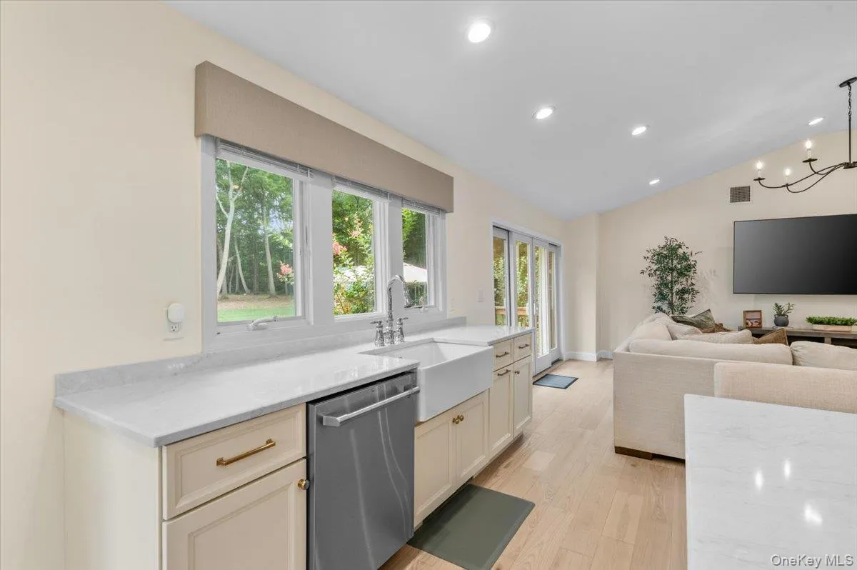 Kitchen with light-toned cabinetry, a farmhouse sink, and light-toned countertops Kitchen with light-toned cabinetry, a farmhouse sink, and light-toned countertops