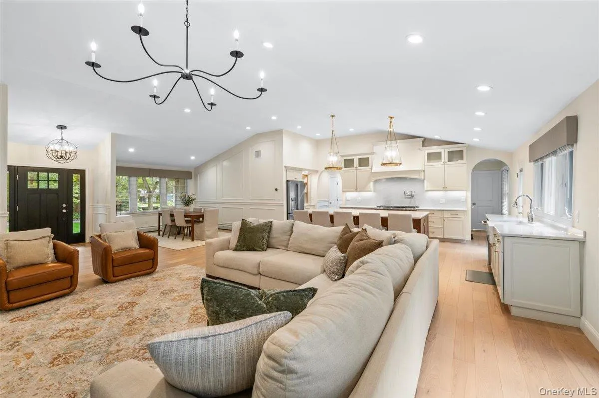 Open concept living space featuring light wood-finish flooring, recessed lighting, and a vaulted ceiling Open concept living space featuring light wood-finish flooring, recessed lighting, and a vaulted ceiling