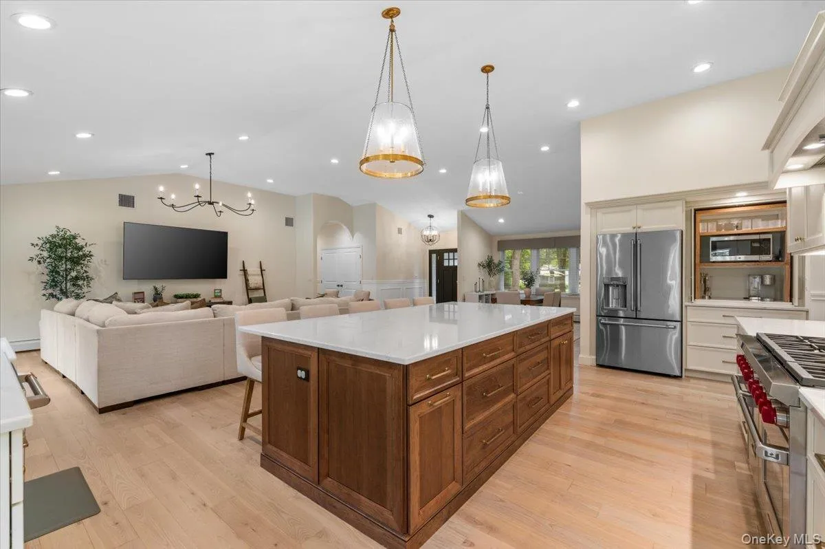 Open-concept living space featuring a vaulted ceiling and light wood-finish flooring Open-concept living space featuring a vaulted ceiling and light wood-finish flooring