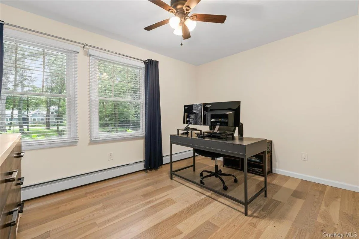 Two large windows, wood-finish flooring, and a ceiling fan with integrated lighting Two large windows, wood-finish flooring, and a ceiling fan with integrated lighting