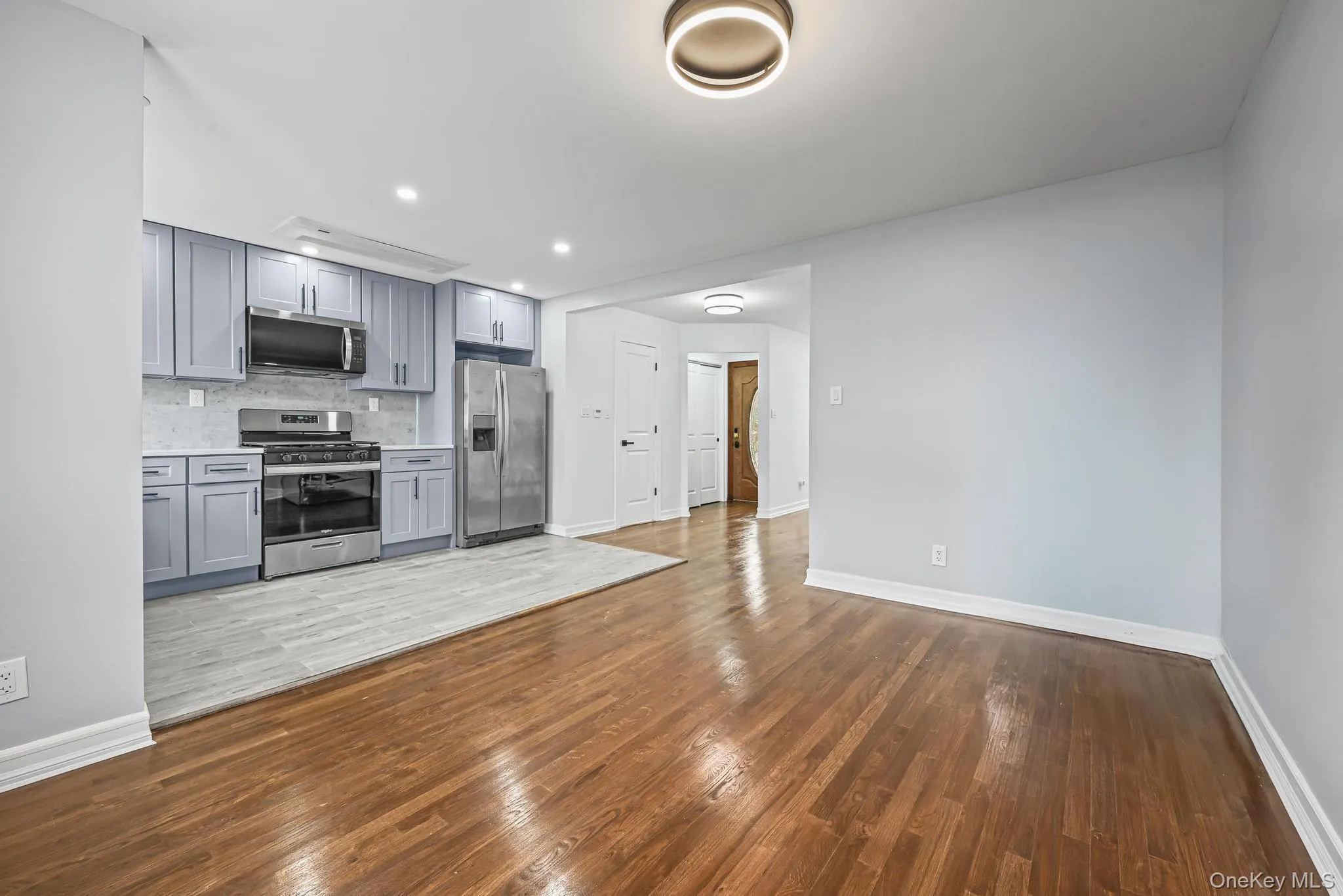Kitchen featuring gray cabinetry, decorative backsplash, dark wood-type flooring, appliances with stainless steel finishes, and recessed lighting Kitchen featuring gray cabinetry, decorative backsplash, dark wood-type flooring, appliances with stainless steel finishes, and recessed lighting