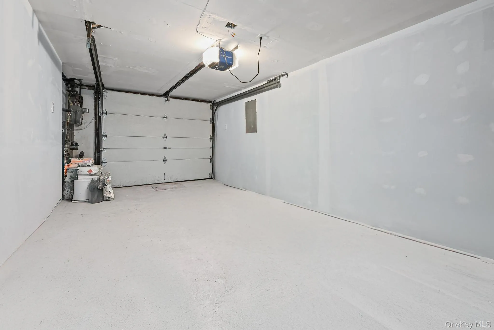 Garage featuring a garage door opener and electric panel Garage featuring a garage door opener and electric panel