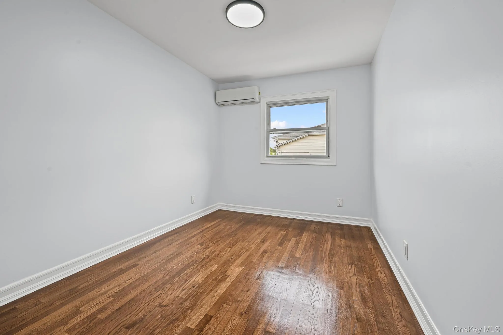Unfurnished room featuring dark wood-type flooring and baseboards Unfurnished room featuring dark wood-type flooring and baseboards