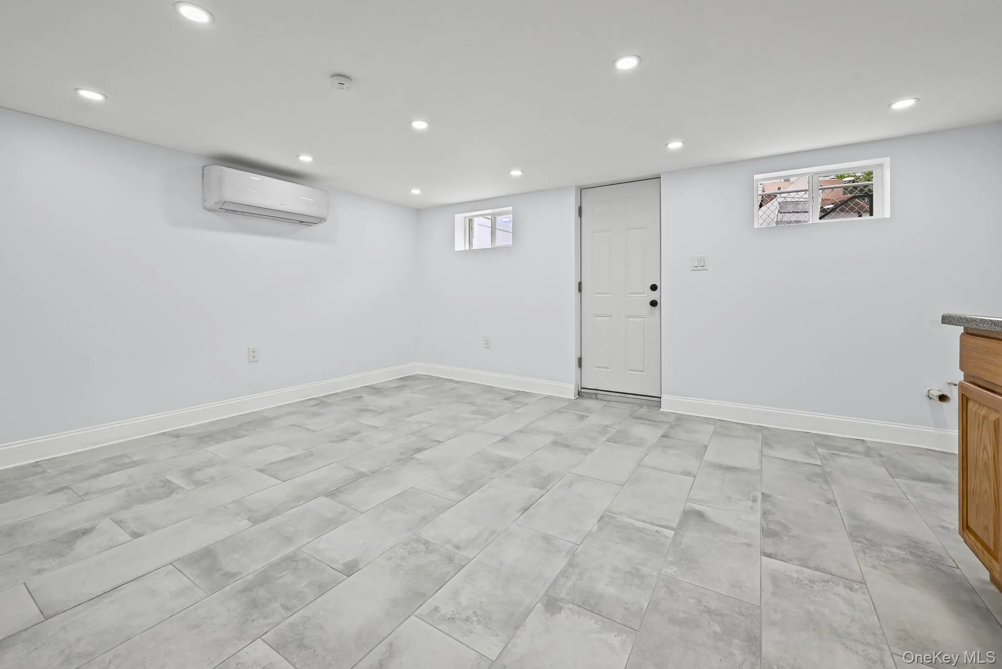 Basement with recessed lighting and a wall mounted AC Basement with recessed lighting and a wall mounted AC
